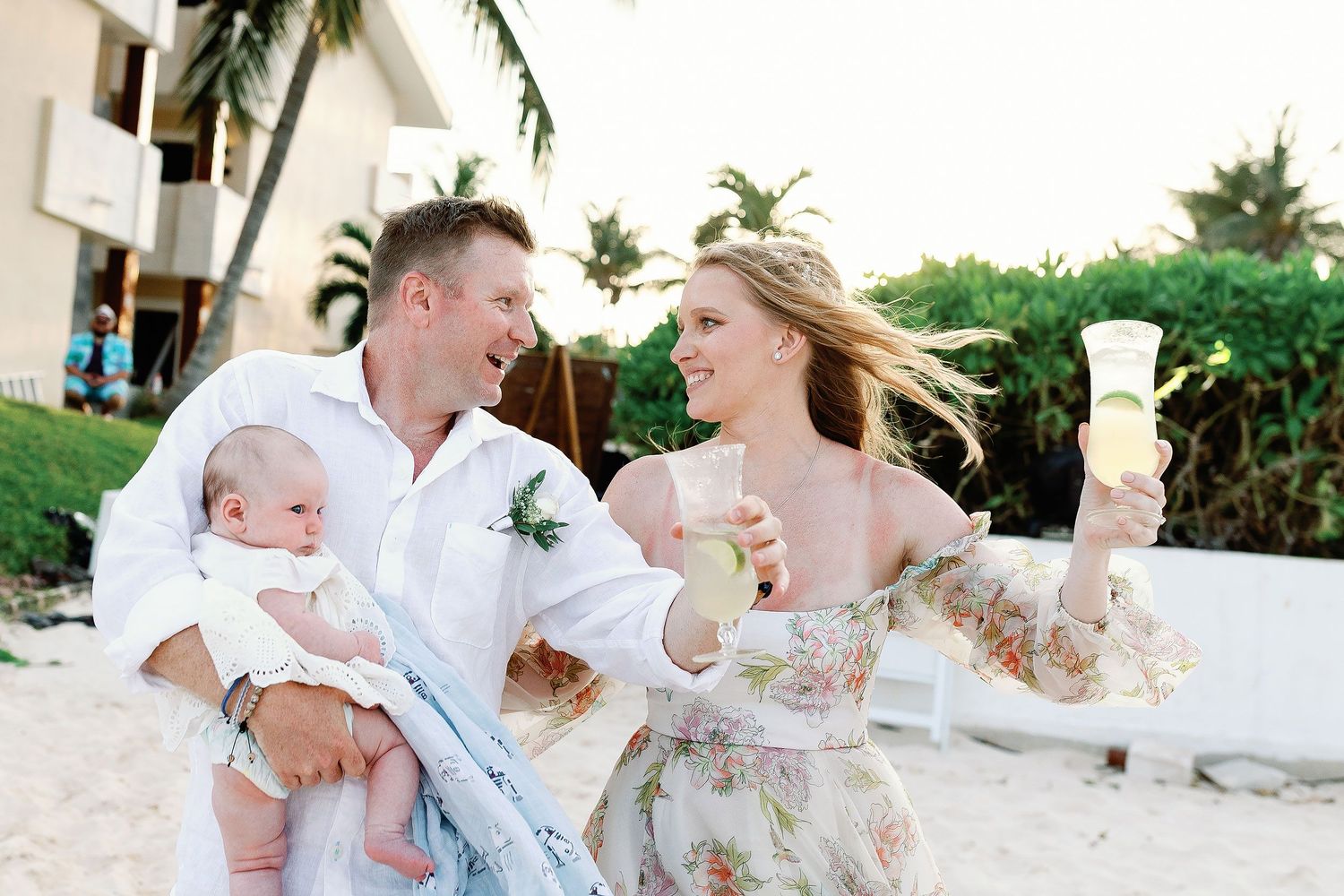 Autumn and Brian celebrating with drinks while holding their baby after their Dreams Sapphire ceremony.