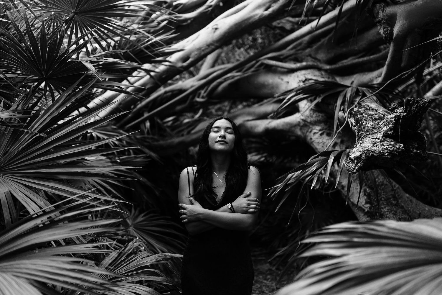 Creative senior portrait in Playa del Carmen featuring lush tropical vegetation and artistic black-and-white photography.