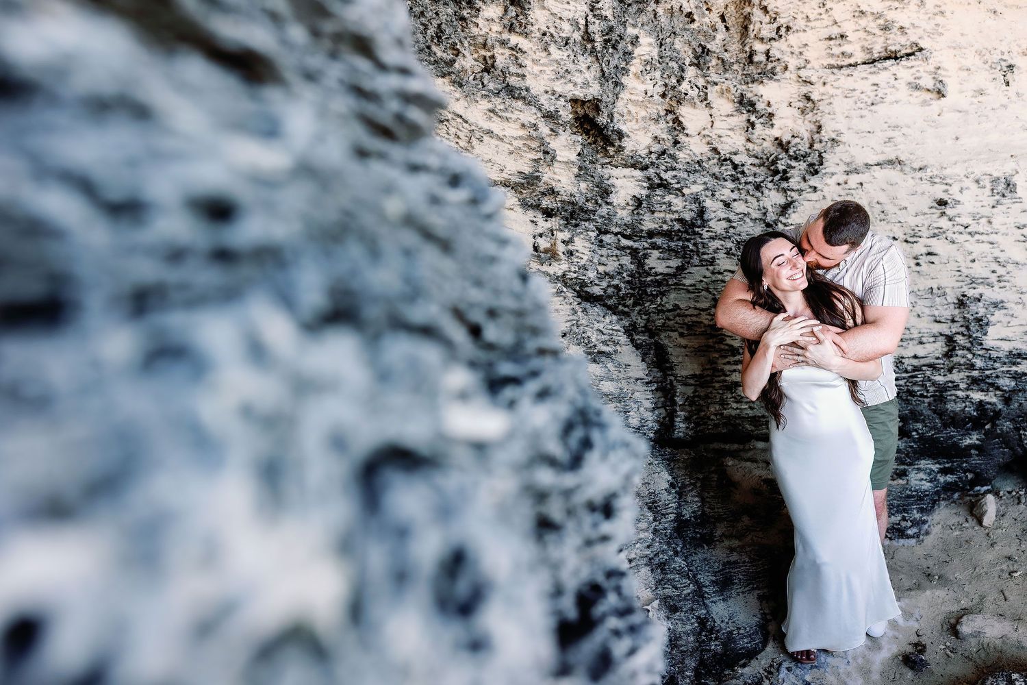 Sam embraces Alexia in a sheltered limestone cove during their Punta Sur engagement session.