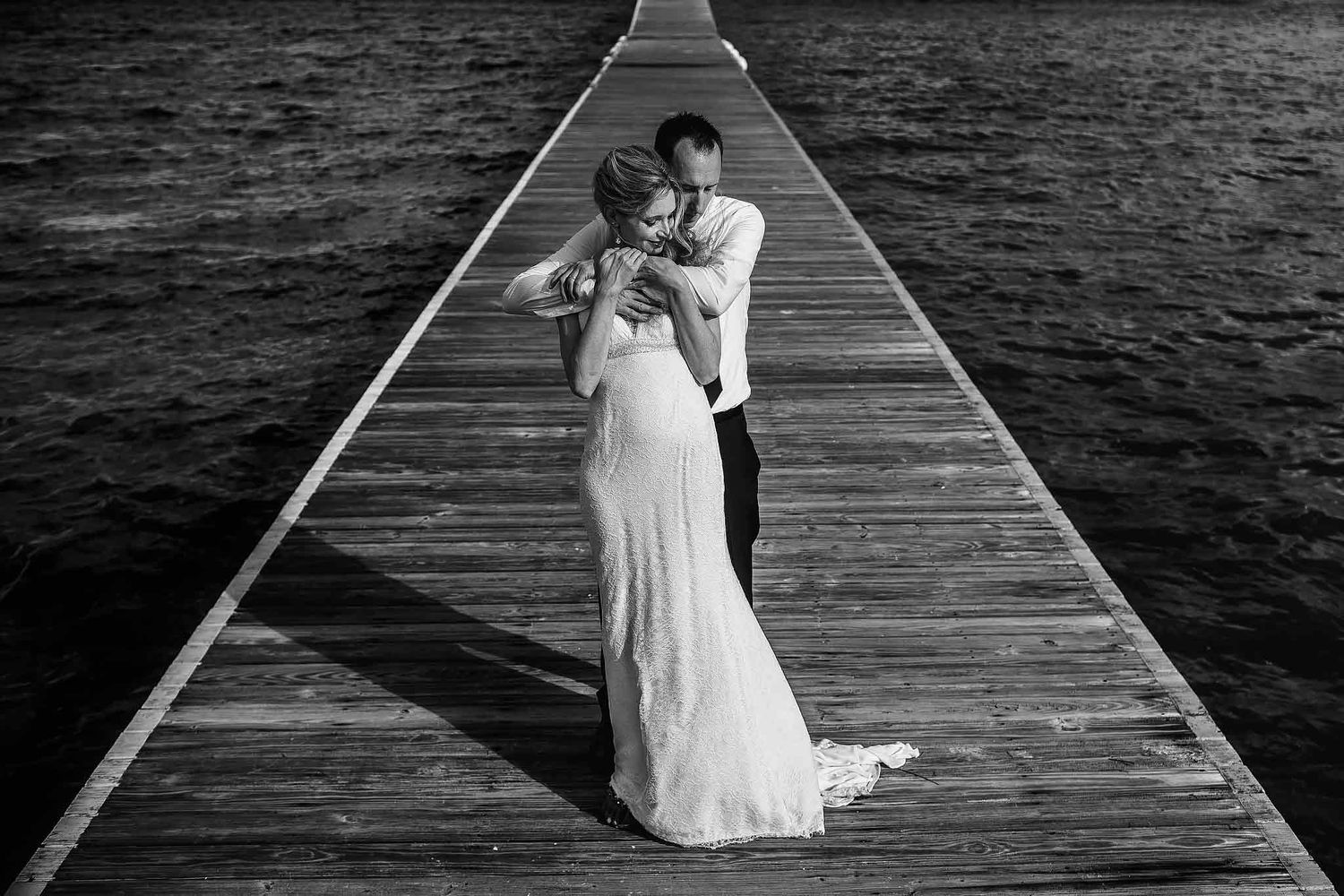 Black and white creative wedding portrait at Secrets Akumal Riviera Maya on a dramatic ocean pier.