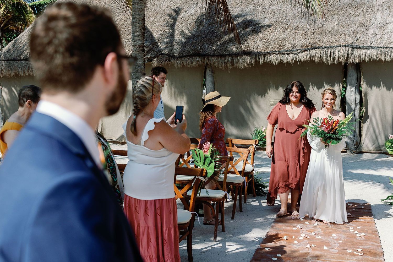 Nicole walks down the aisle toward Thomas during their intimate beachfront wedding ceremony at Blue Venado in Playa del Carmen.
