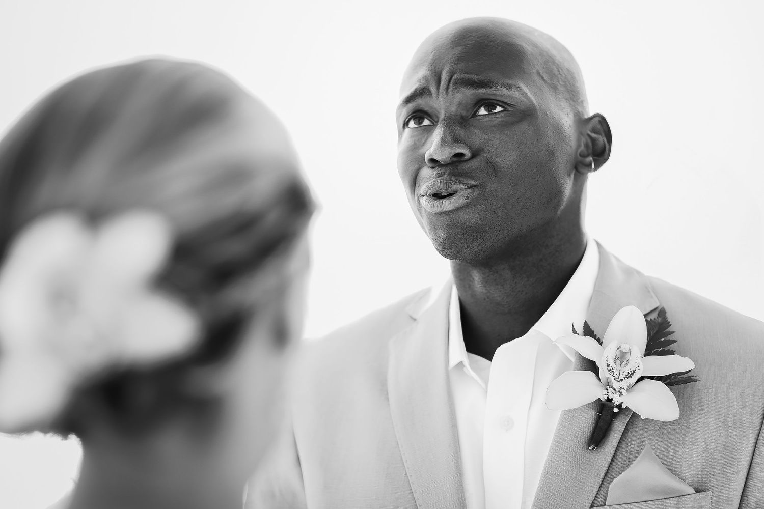 Black-and-white close-up of an emotional groom exchanging vows with his bride during their ceremony at Barceló Maya Grand Resort.