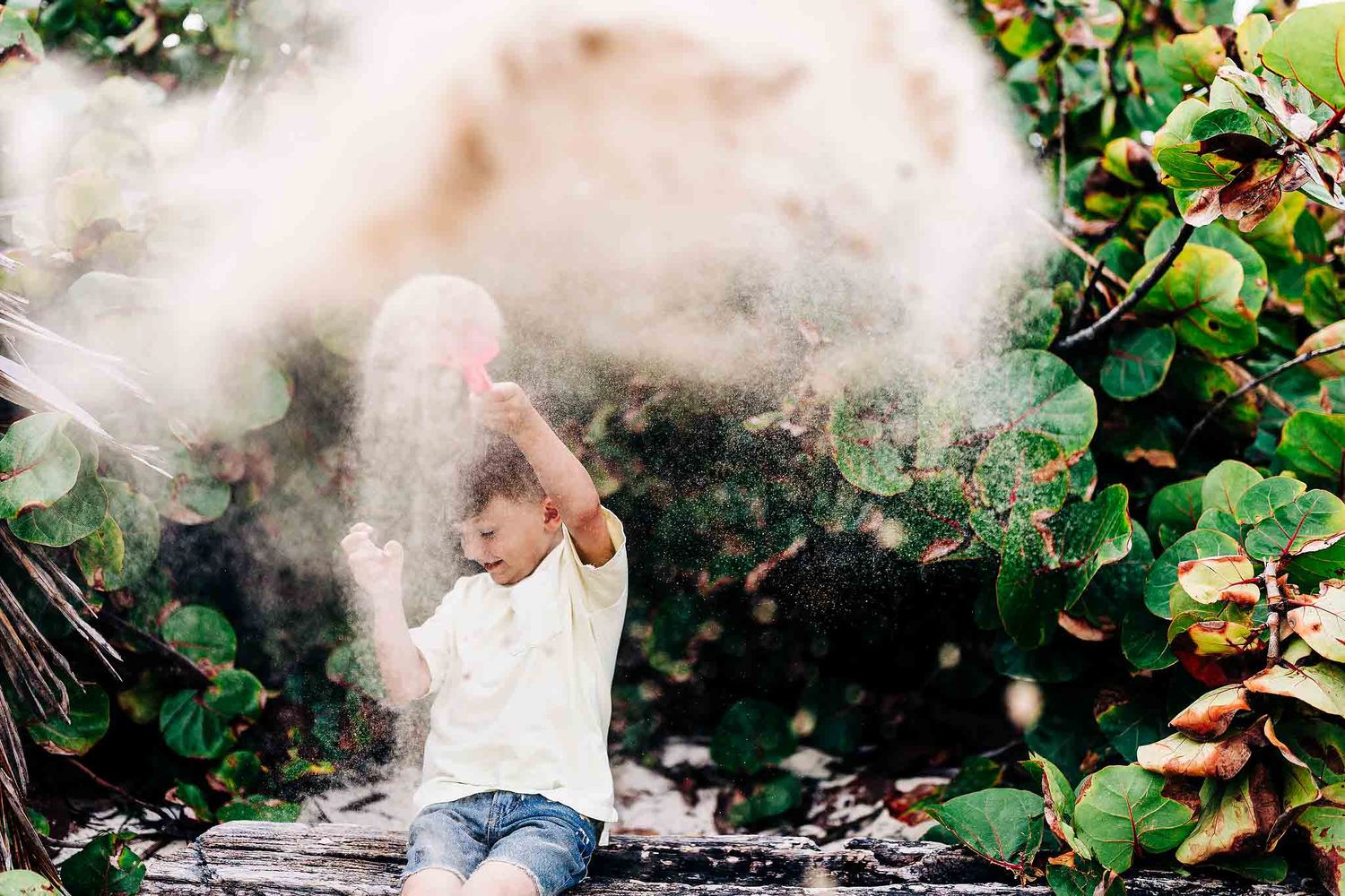 Child playing with sand during a family photography session at Punta Esmeralda beach