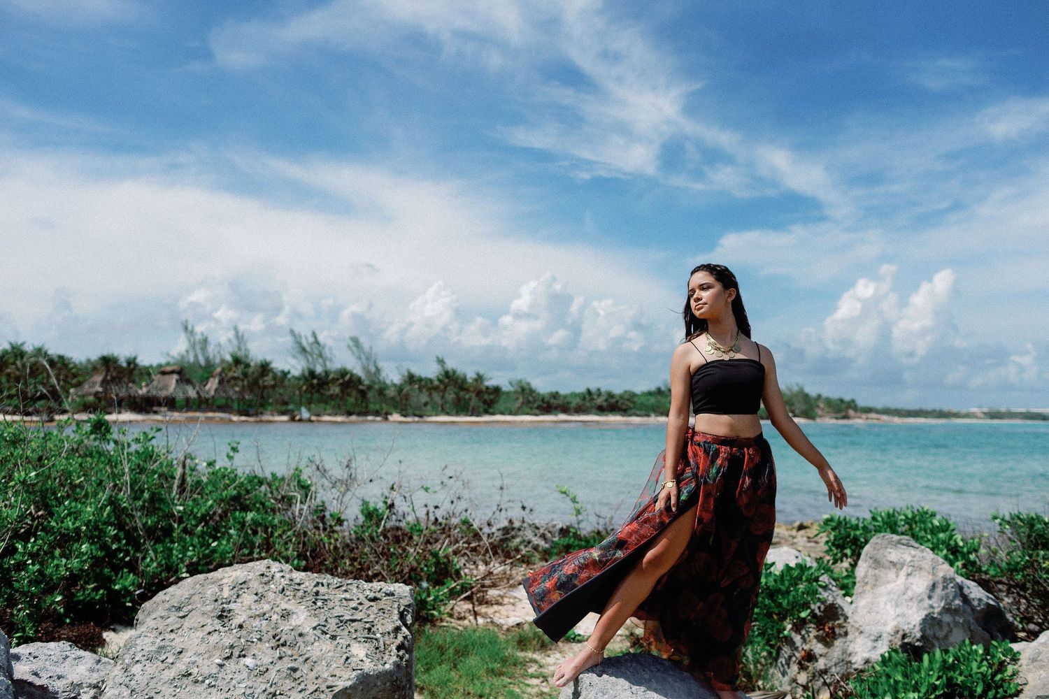 Senior portraits in Riviera Maya with ocean views, natural limestone rocks, and a tropical Caribbean coastline backdrop.