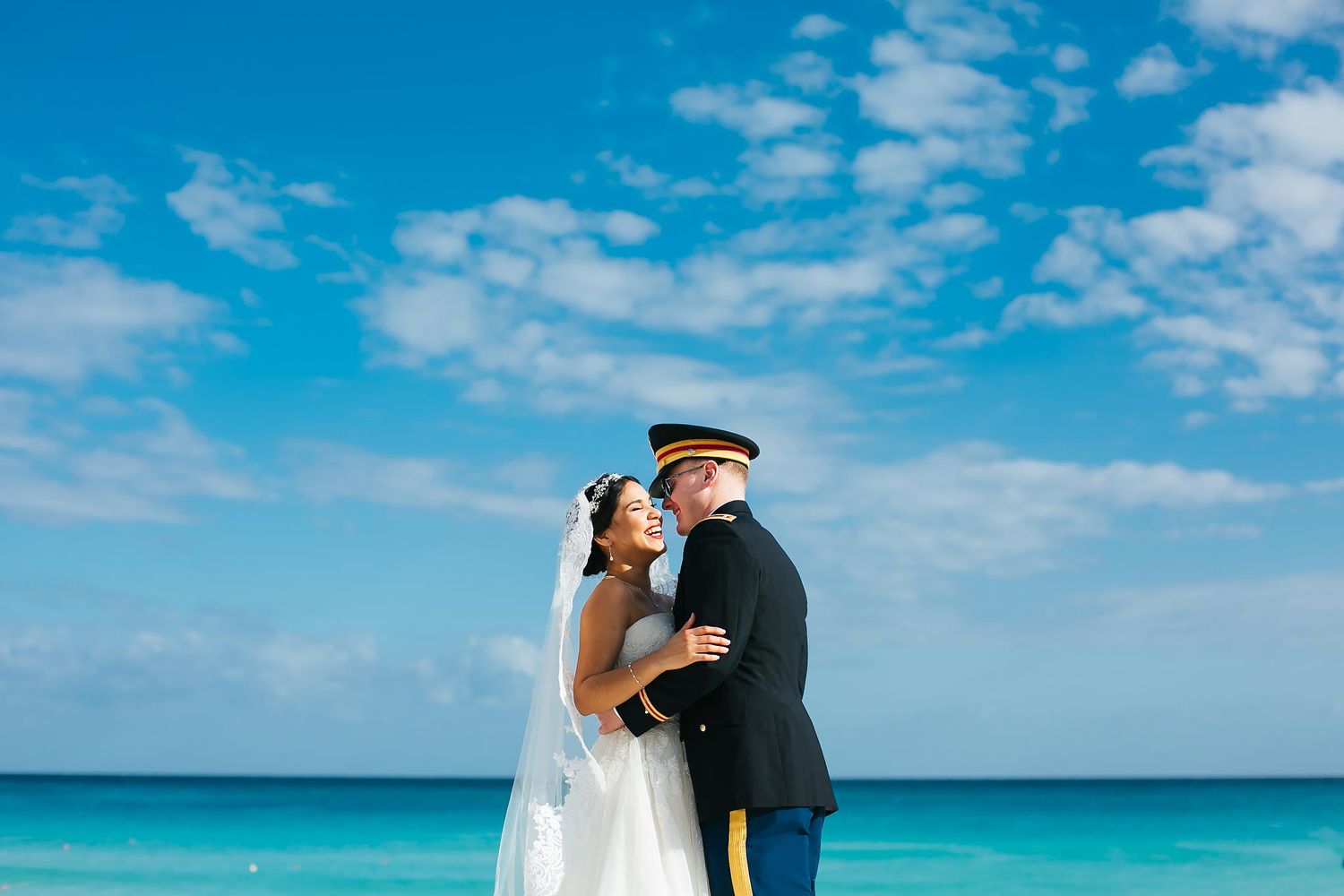 Elegant beach wedding portrait at Iberostar Cancun, capturing a joyful moment between a bride and groom in luxury attire by the Caribbean