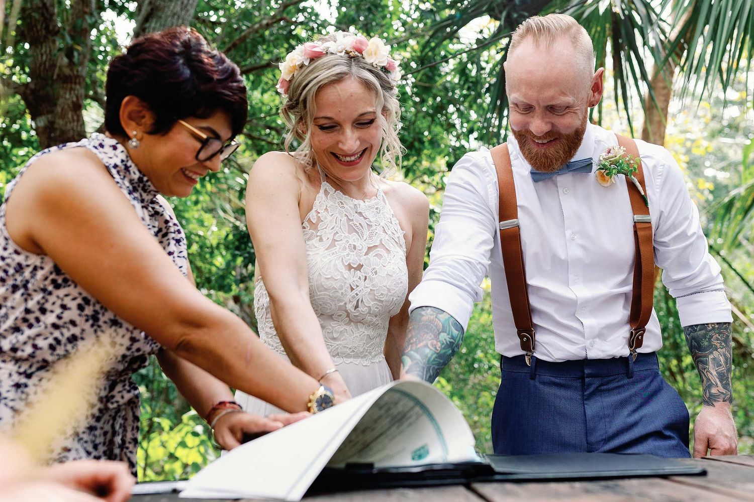 Jeff and Veronica smiling as they sign their civil marriage documents during their intimate Cenote Hats’uts wedding near Playa del Carmen.