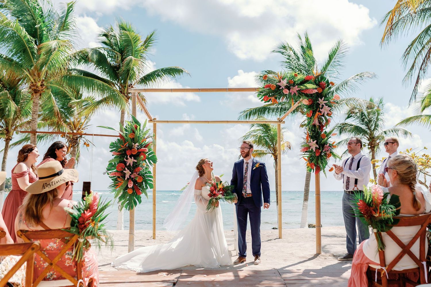 Nicole and Thomas laughing together during their intimate beachfront wedding ceremony at Blue Venado in Playa del Carmen.