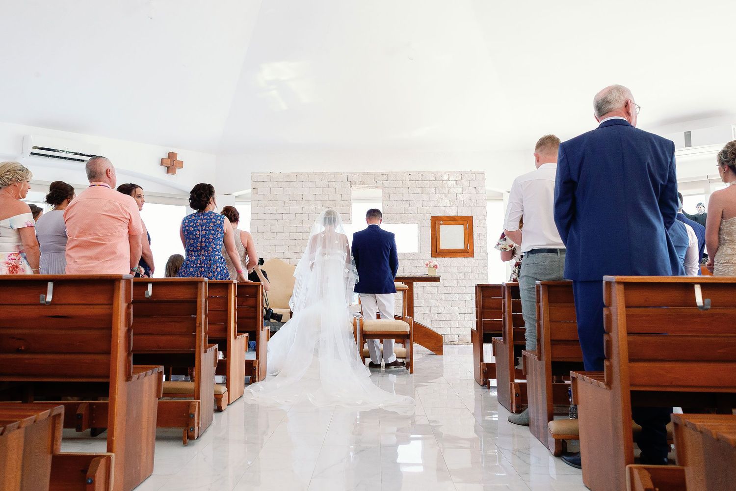 Bride and groom during a Catholic wedding ceremony at San Charbel Chapel in Hard Rock Riviera Maya surrounded by family and guests