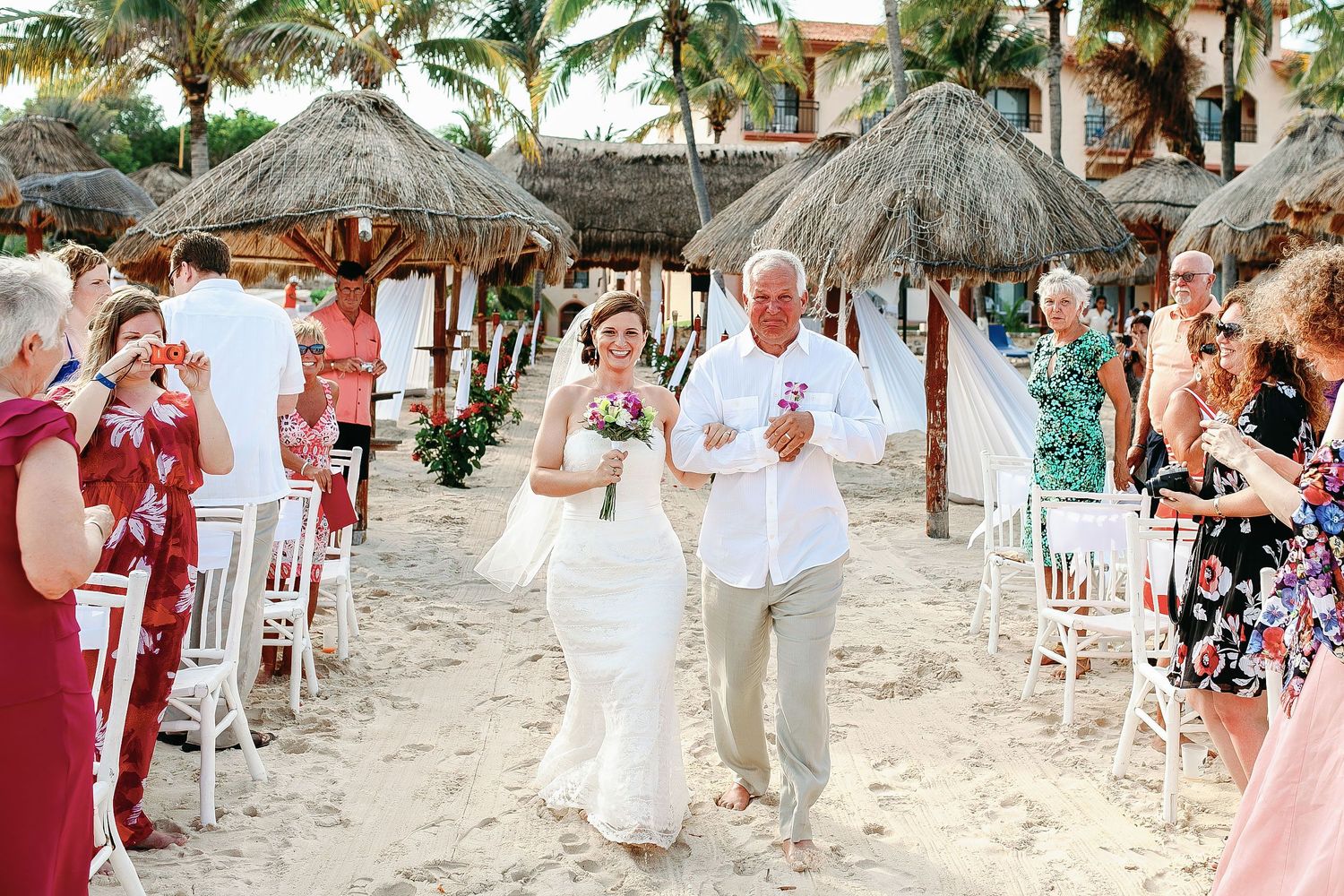 Bride walking with her father during a natural beach wedding ceremony by Luckie Photography in Mexico