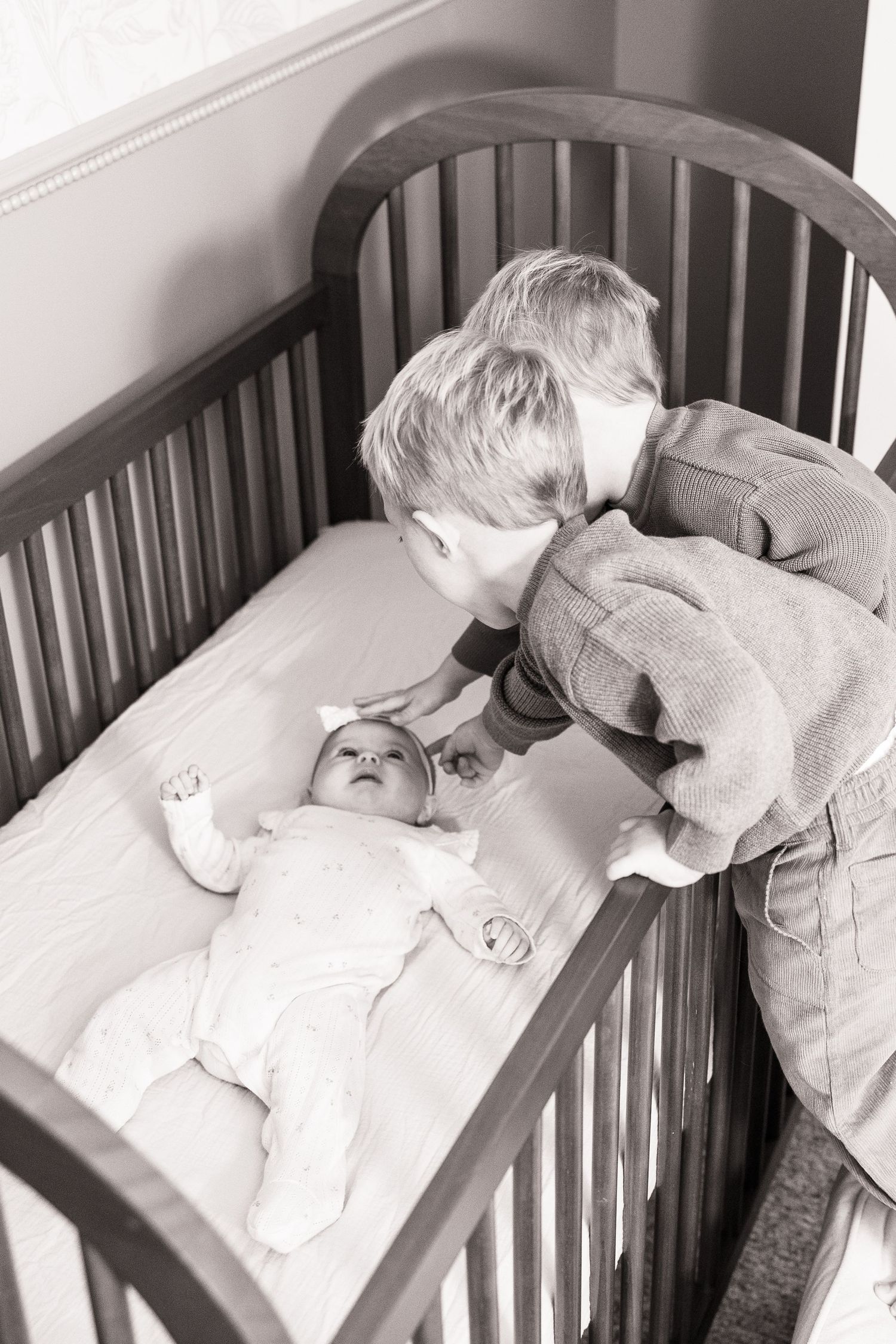 Series of monochrome images showing a baby resting peacefully in a wooden crib.