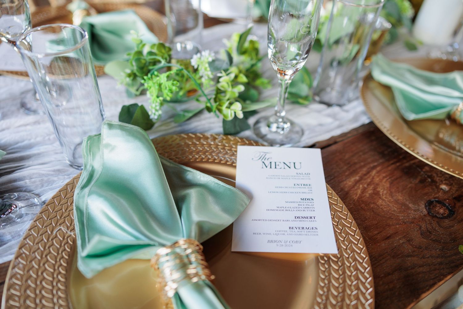 Elegant wedding table settings with mint green napkins and gold chargers on textured linens.