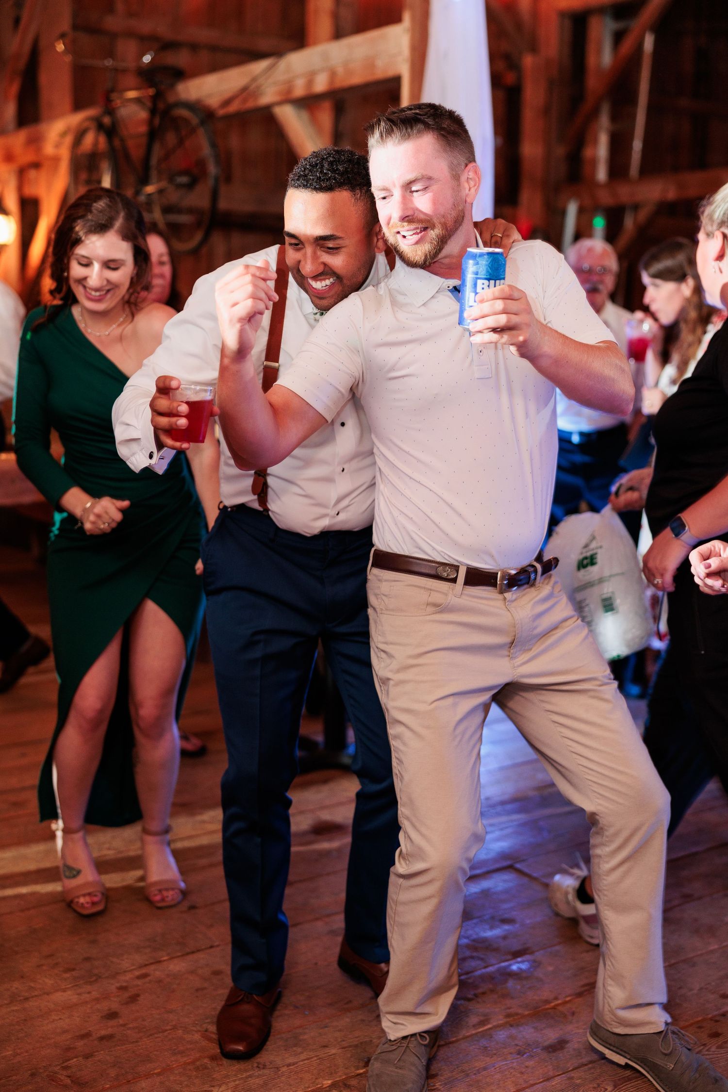 Guests dancing and having fun at a rustic barn wedding reception.