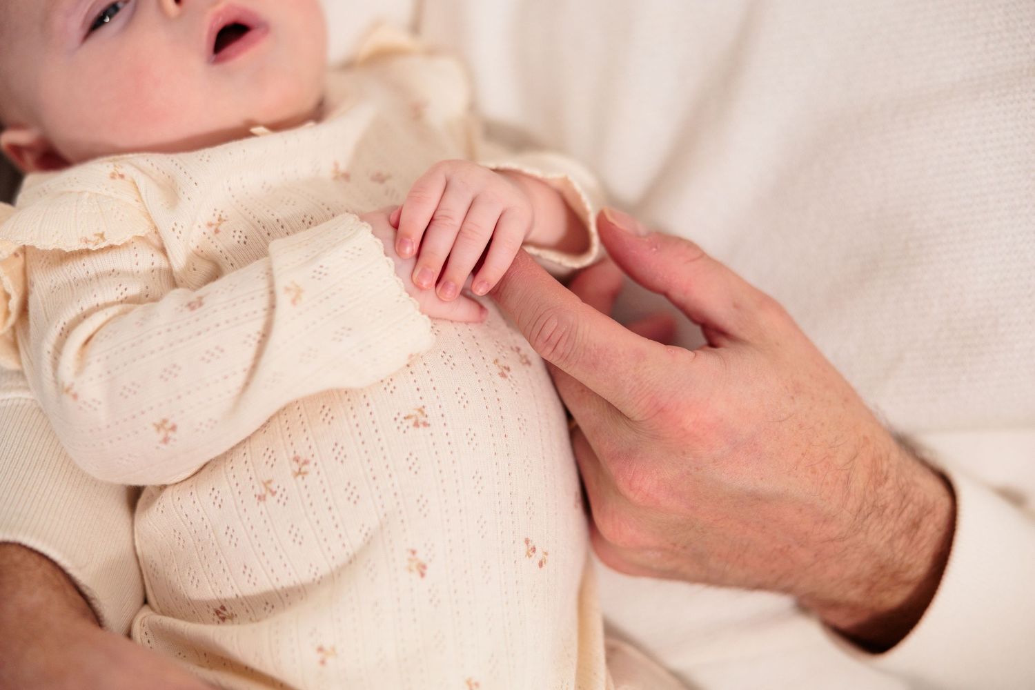 Close-up series of tender moments between parent and infant showing gentle touches and bonding.