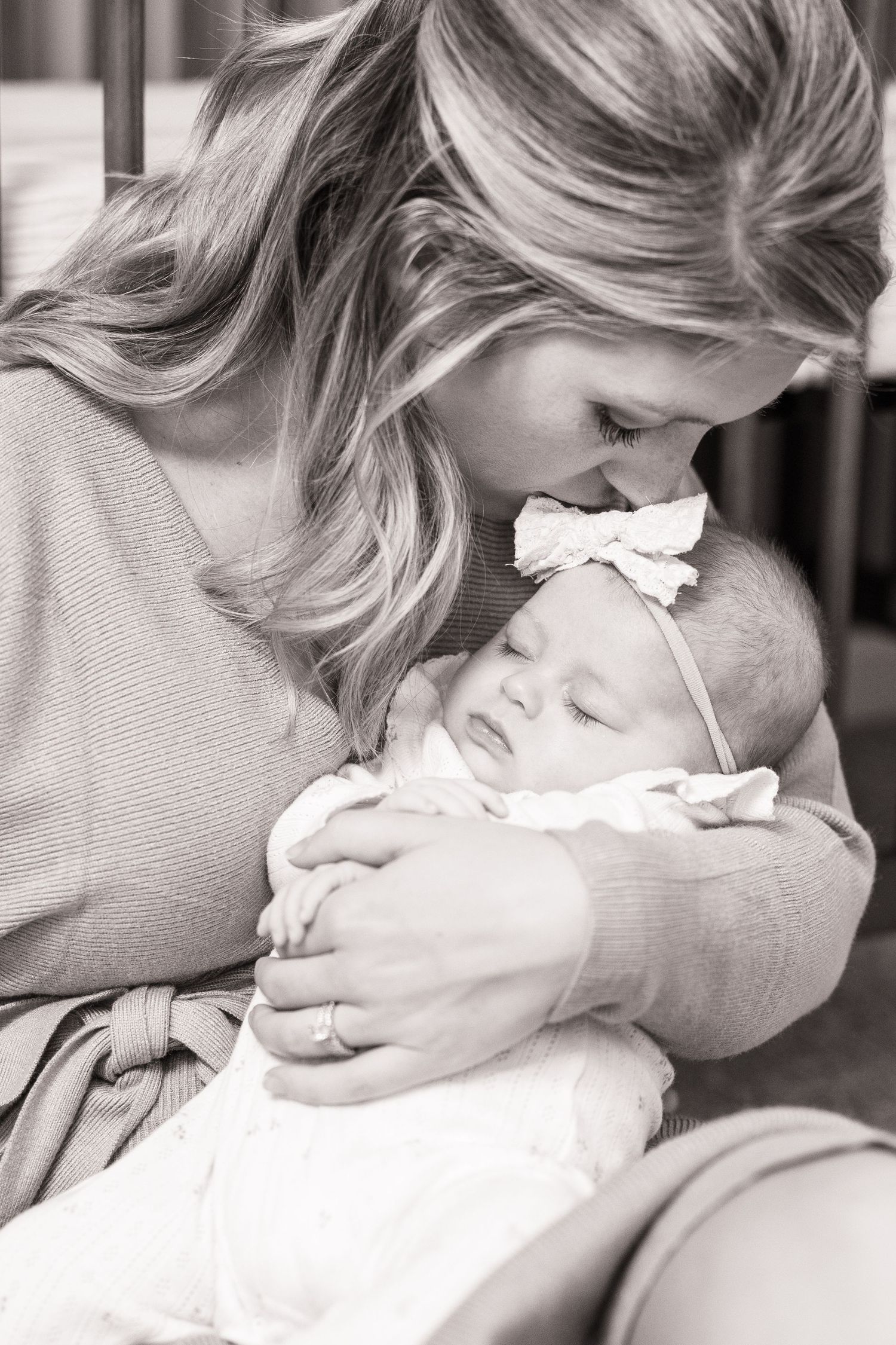 Black and white photo series capturing gentle moments with a newborn baby.