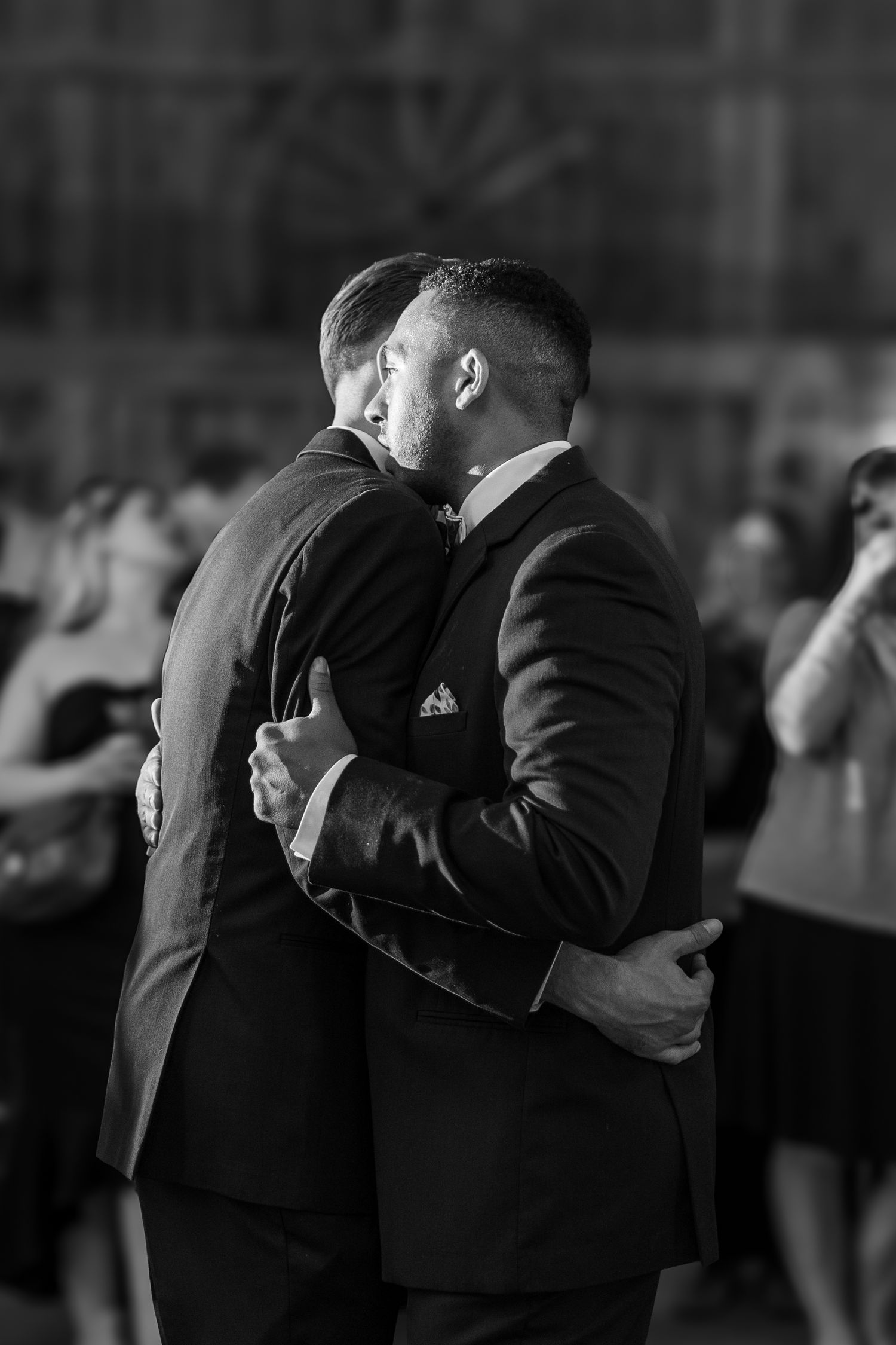 A black and white photo captures two people dancing closely at a formal event.