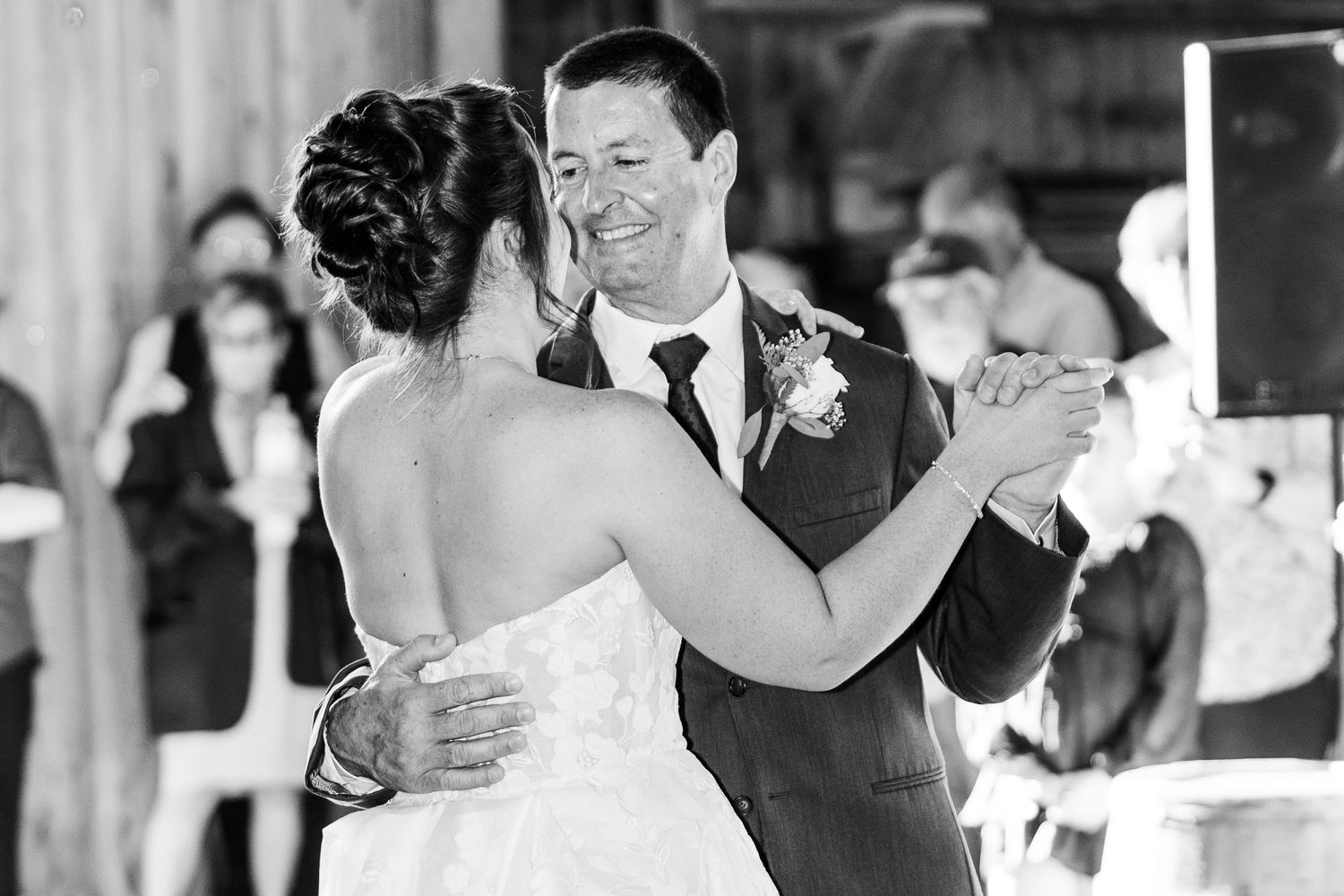 Wedding reception dance moments captured inside a rustic venue.
