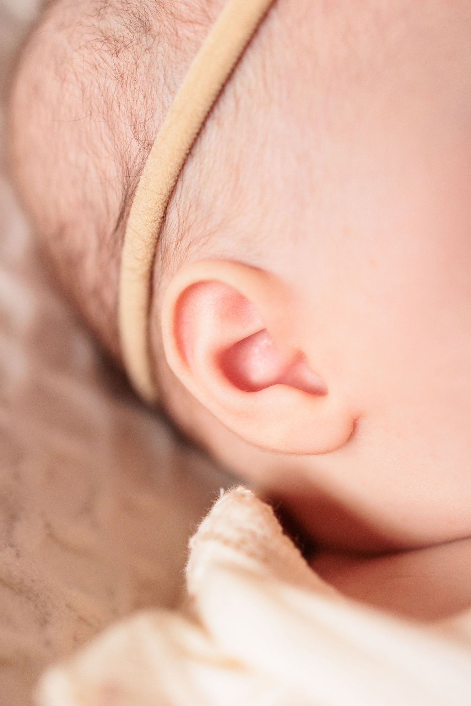 Macro detail shots focusing on a sleeping baby's delicate features and ear.