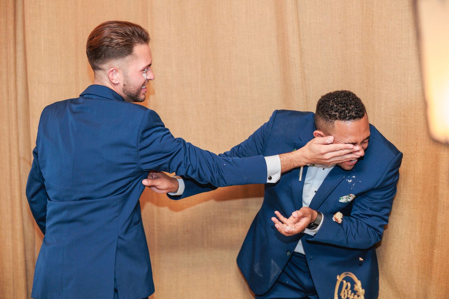 Candid dancing sequence showing joyful celebration between two people in matching navy suits.