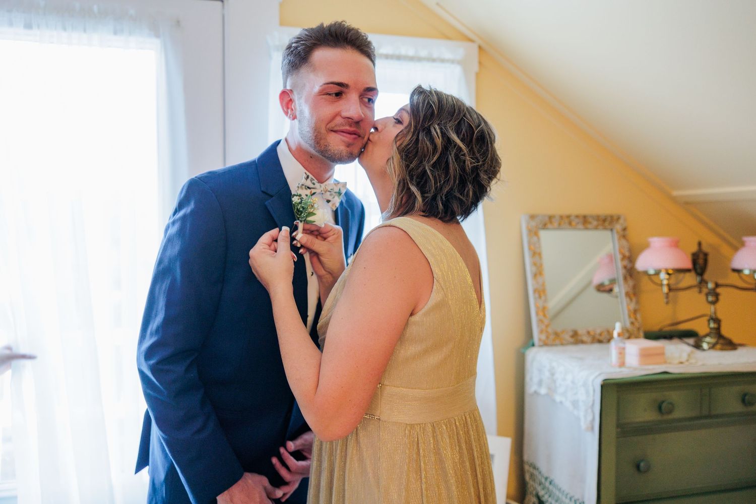 Wedding preparation scene in a sunlit room with vintage furniture.