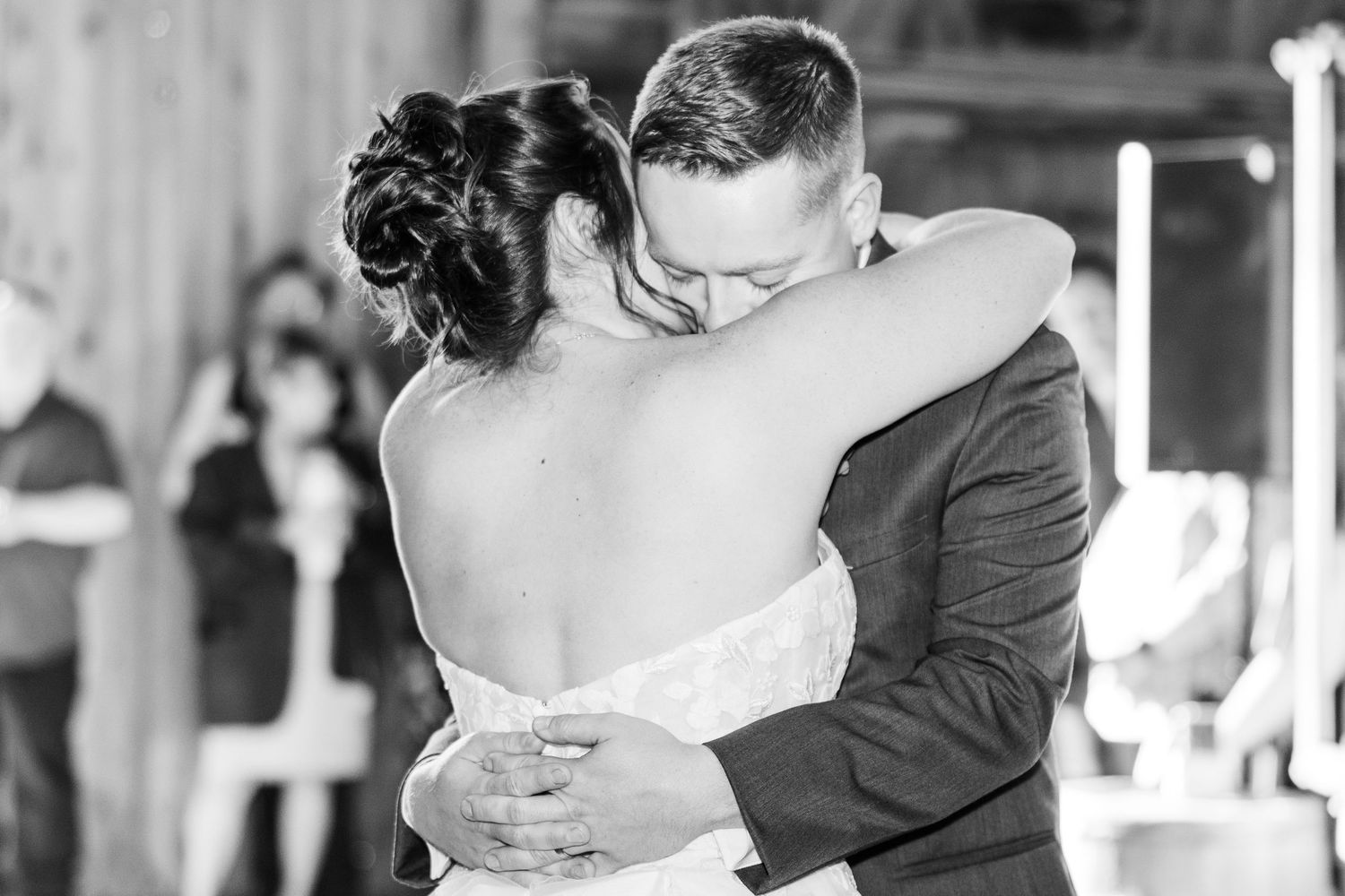 Black and white wedding dance photos showing intimate moments between newlyweds in rustic venue.