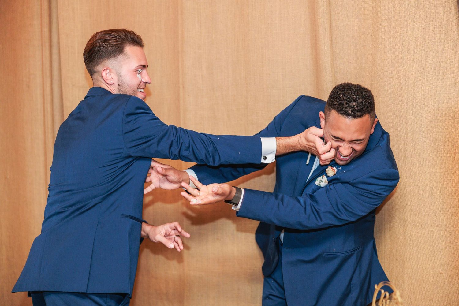 Sequence of playful dance moves between two people in navy suits against a neutral background.