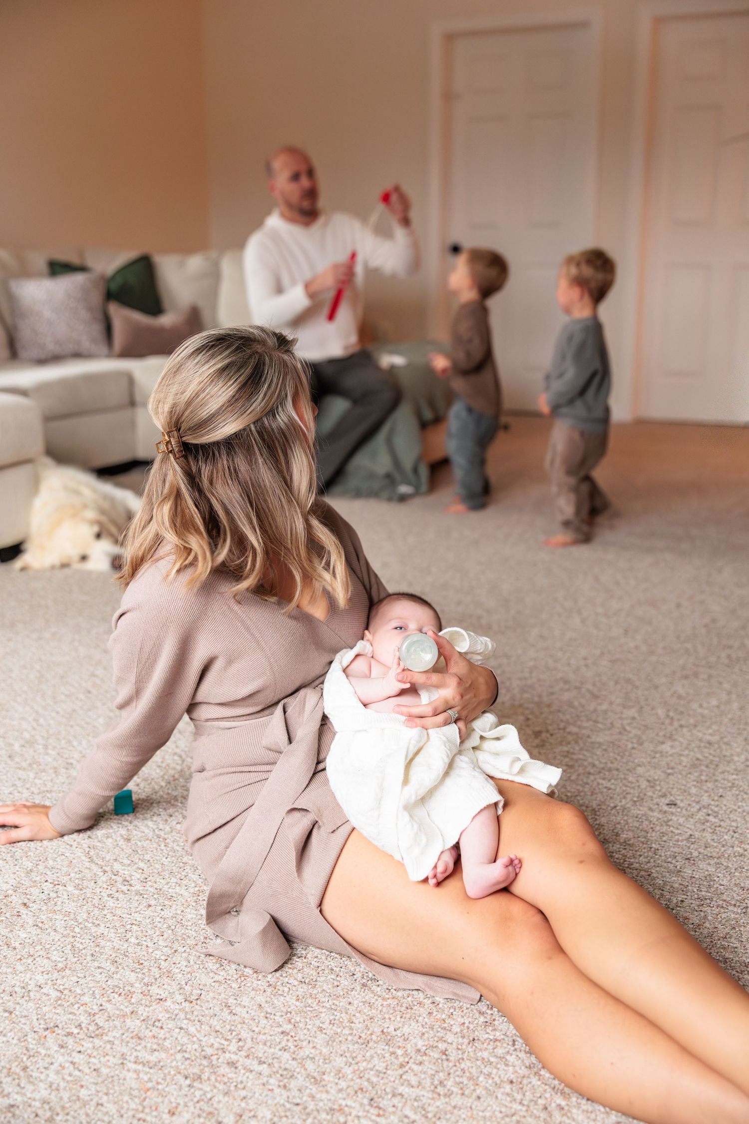 A series of candid photos showing a baby crawling on beige carpet wearing a light gray onesie.