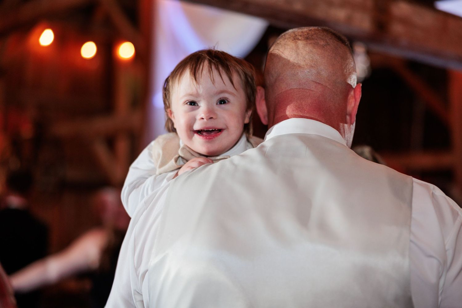 Guests dancing and celebrating during a joyful moment at a barn reception.