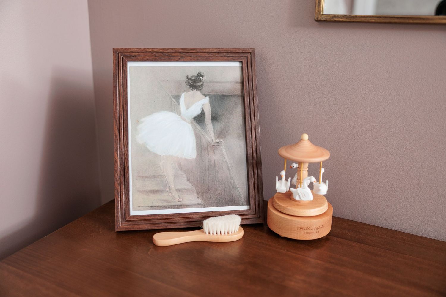 Decorative home interior with wooden furniture, framed artwork, and ceramic accessories on display.