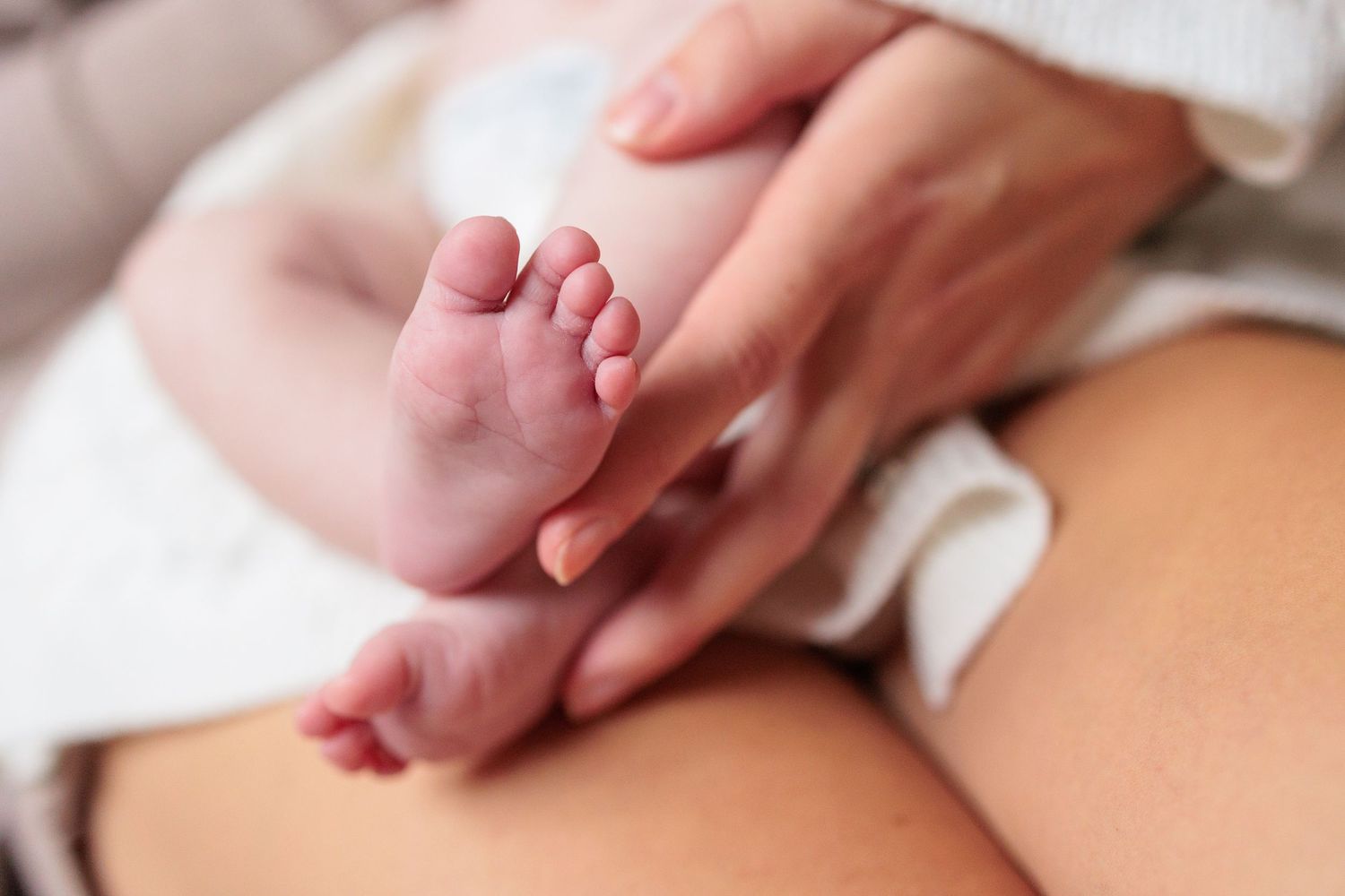 Close-up detail shots of gentle hands touching during an intimate family moment.