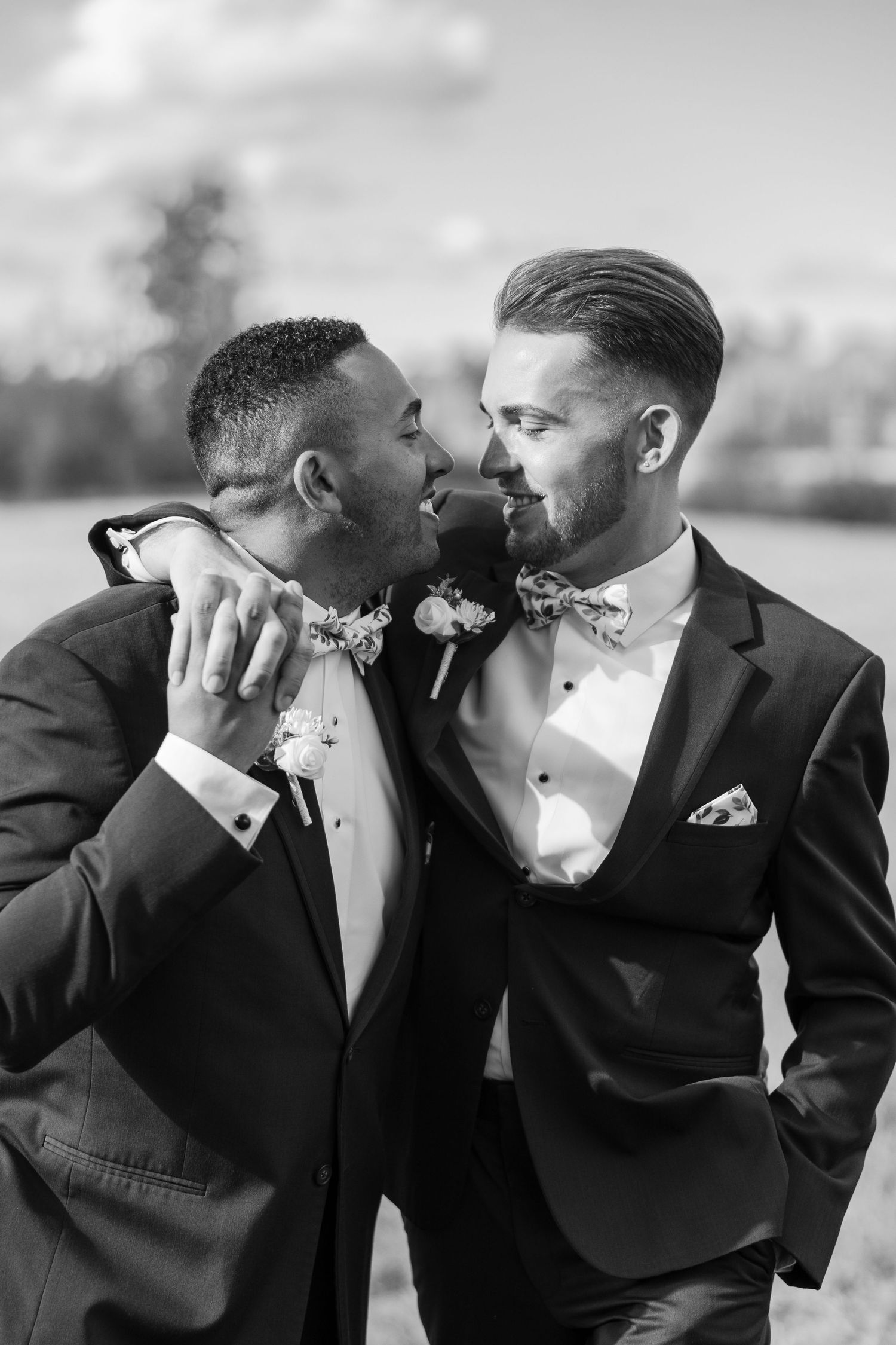 Black and white portrait of couple sharing intimate moment in formal attire.