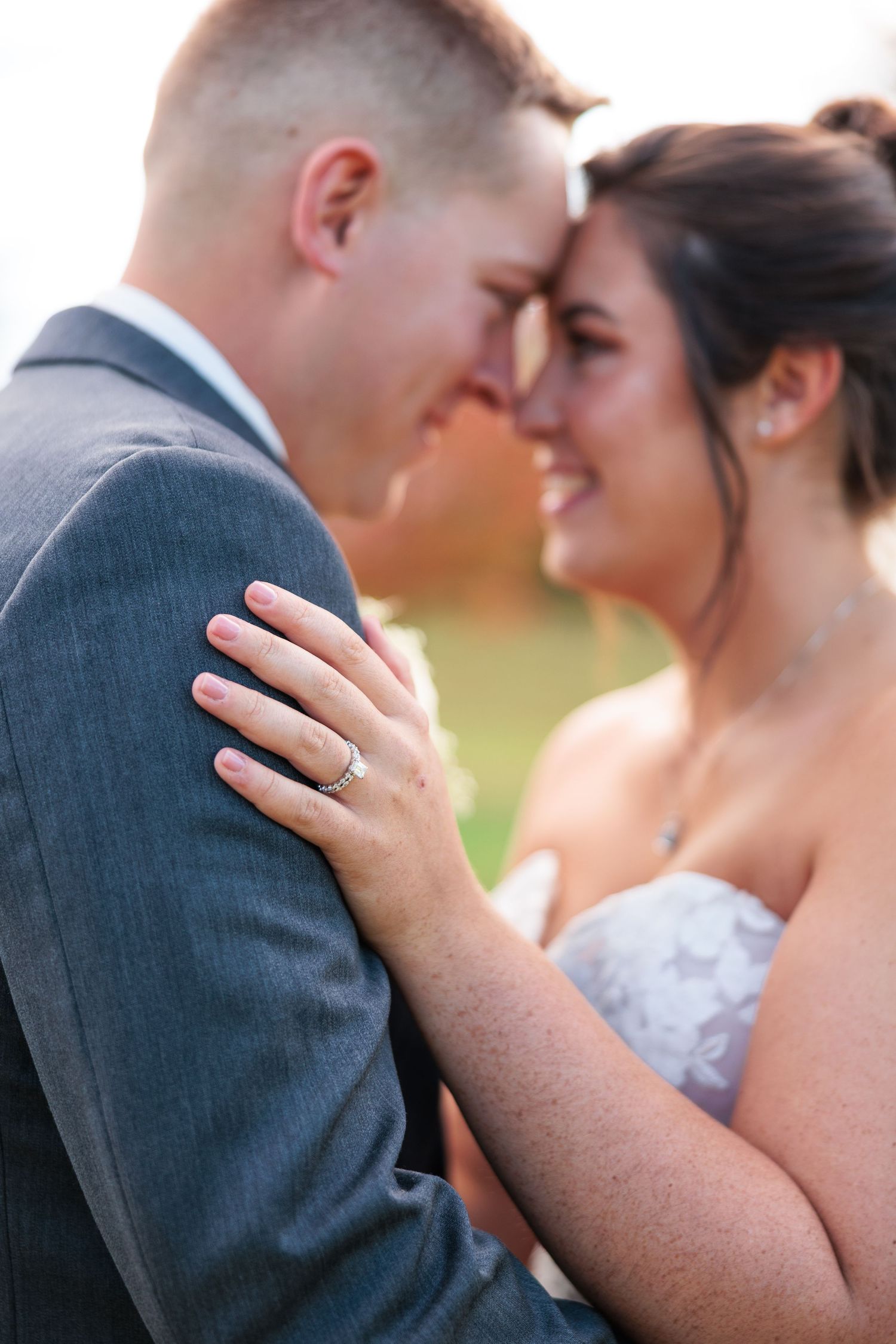 An intimate wedding moment captured as a couple shares a tender embrace outdoors.