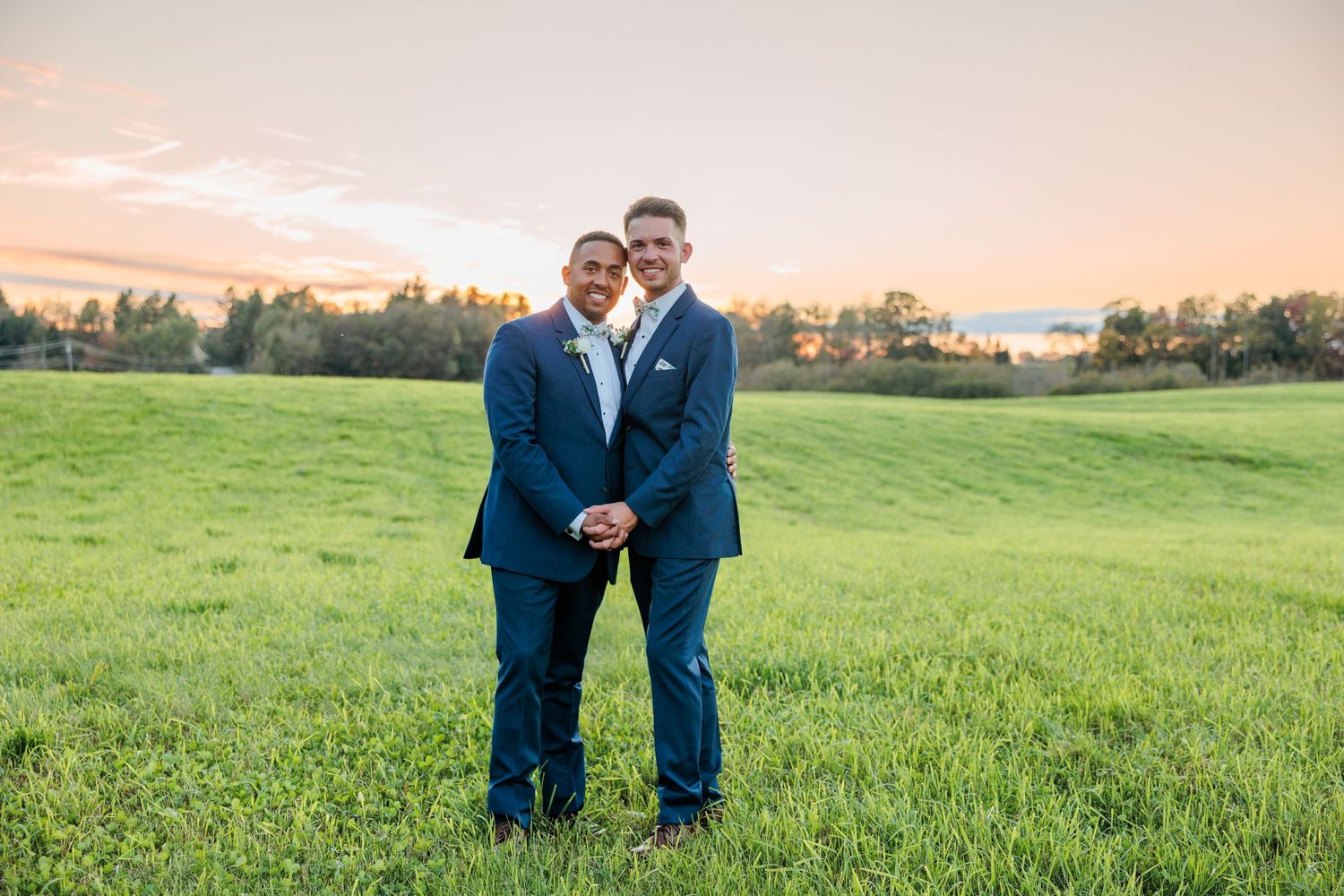 Sunset wedding photography session in a scenic field with rolling hills in the background.
