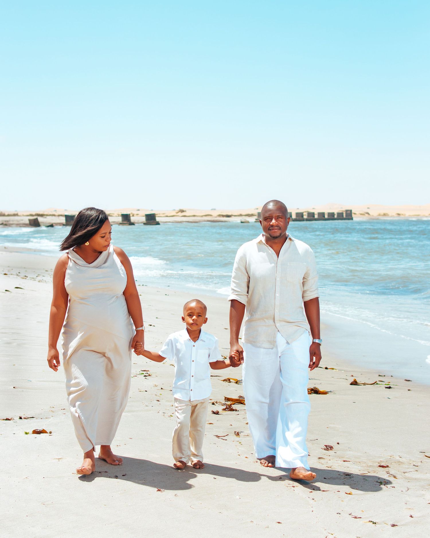 family photoshoot of couple walking by the beach in swakopmund photographed by Walvis Bay photographer