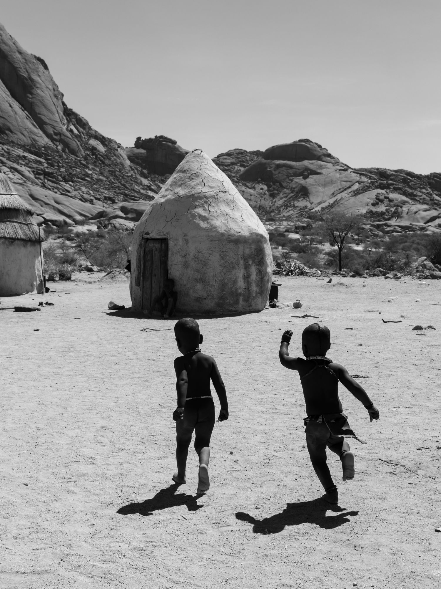 beautiful image of Himba children running excitedly highlighting high standard of peace within the community in Namibia close to Spitzkoppe