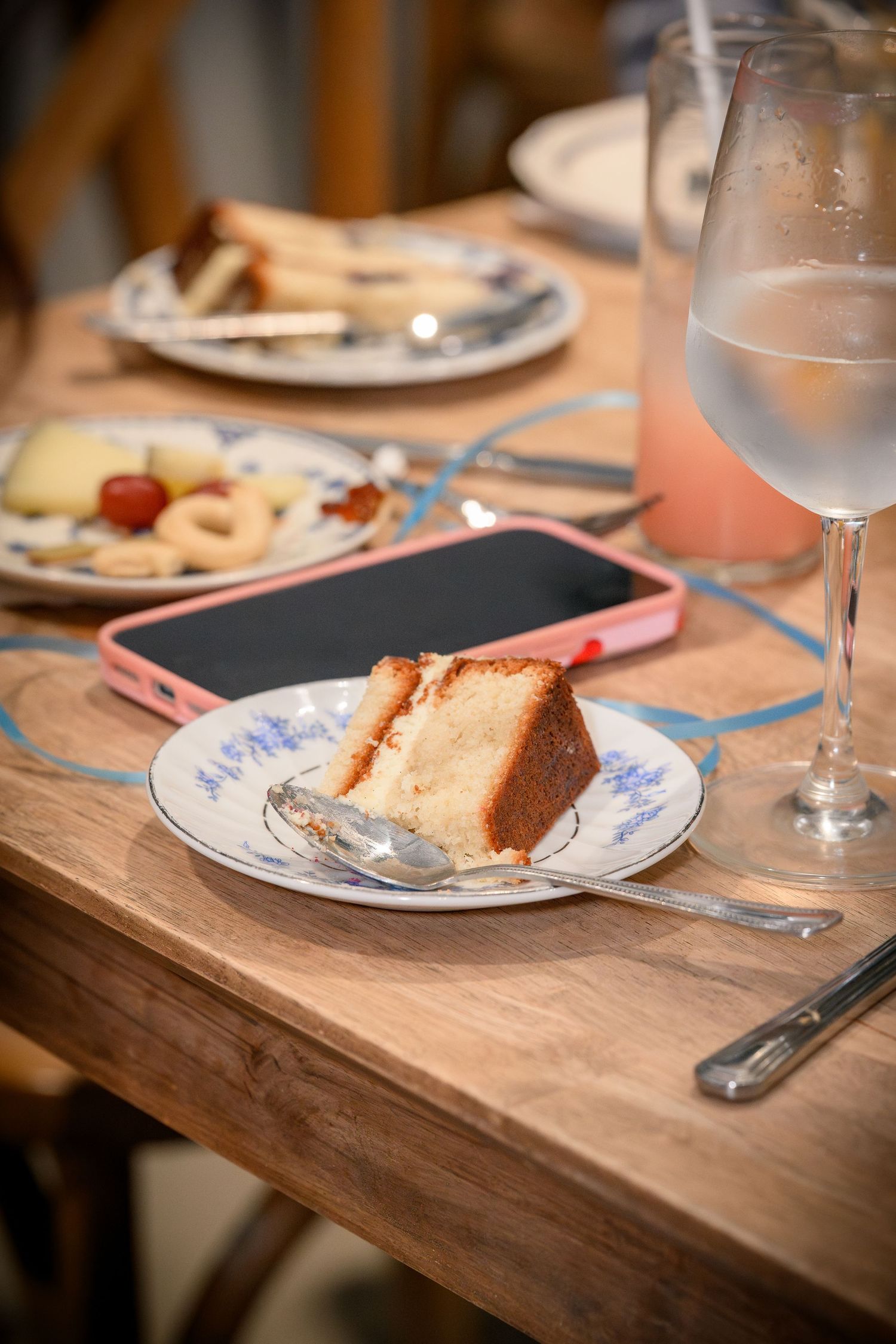 Half-eaten slices of bread and crumbs remain on blue and white patterned plates on a rustic wooden dining table.