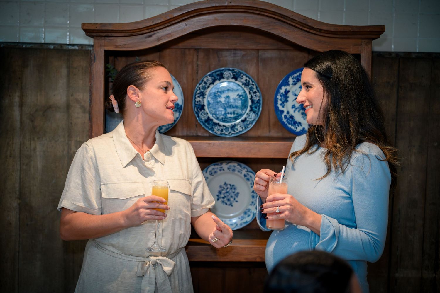 A couple shares intimate moments while holding blue and white decorative plates in a dimly lit room.
