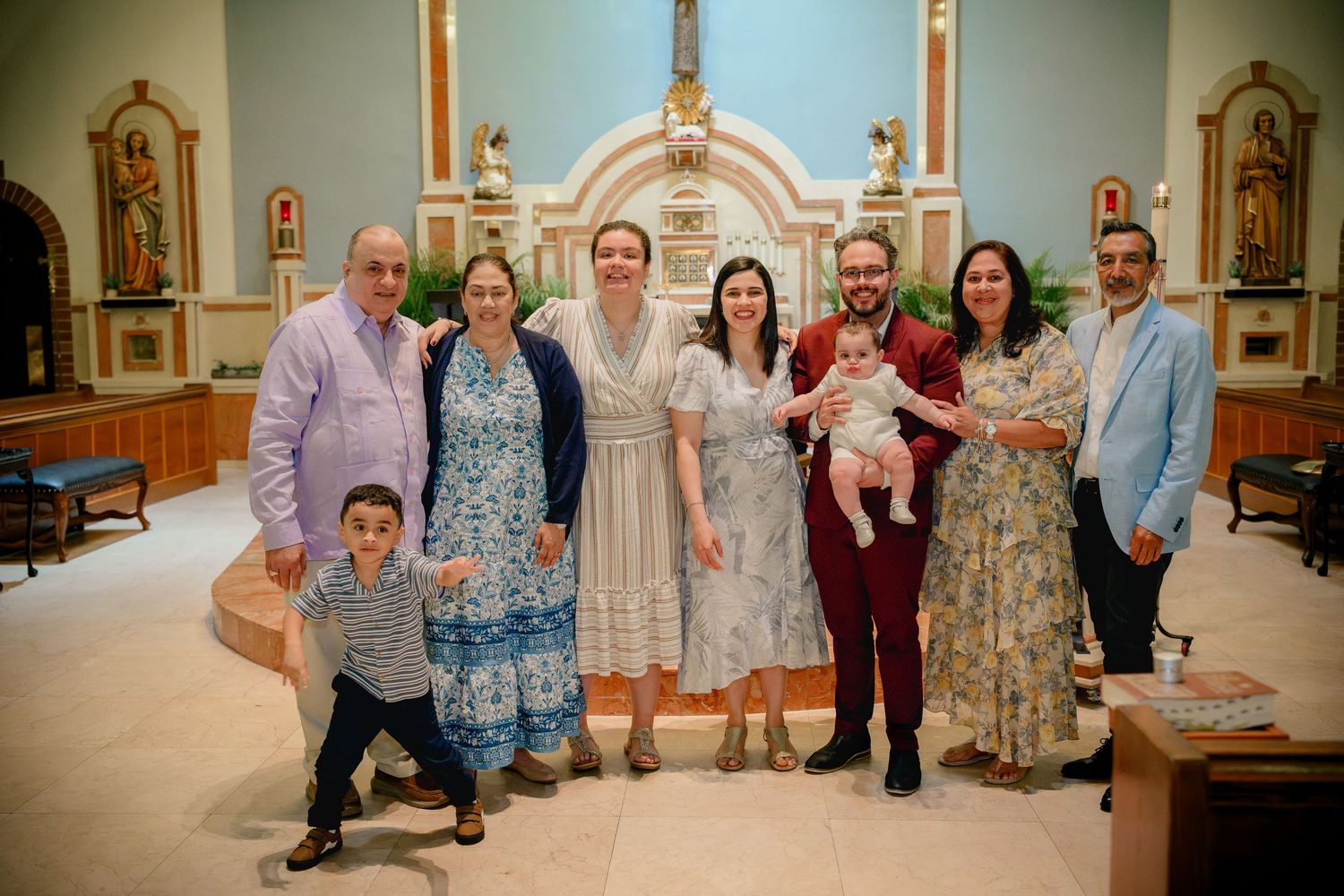 A group of people gather in a church or religious building interior for a celebratory event.