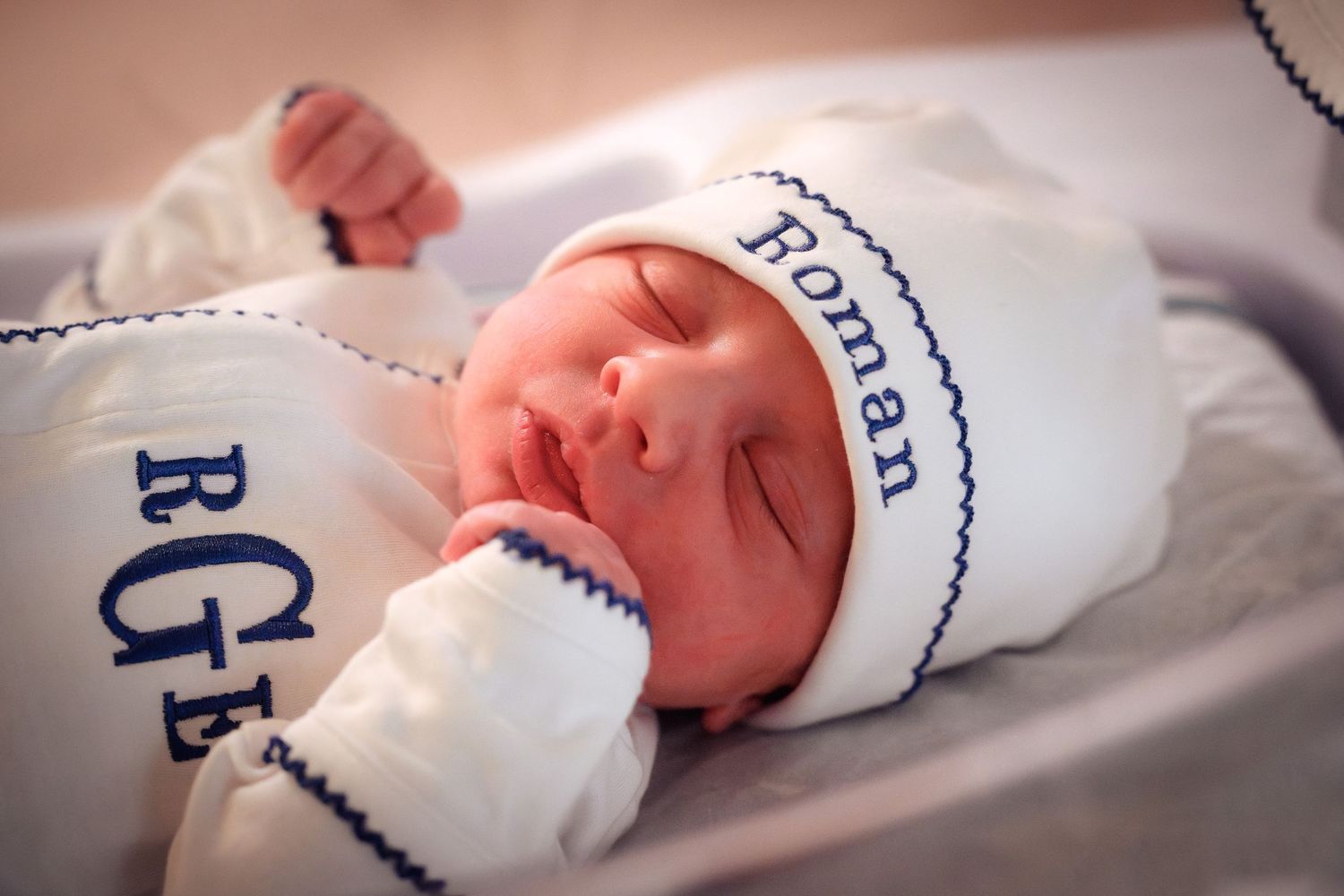 A collage of newborn baby hands and feet wrapped in white hospital blankets.