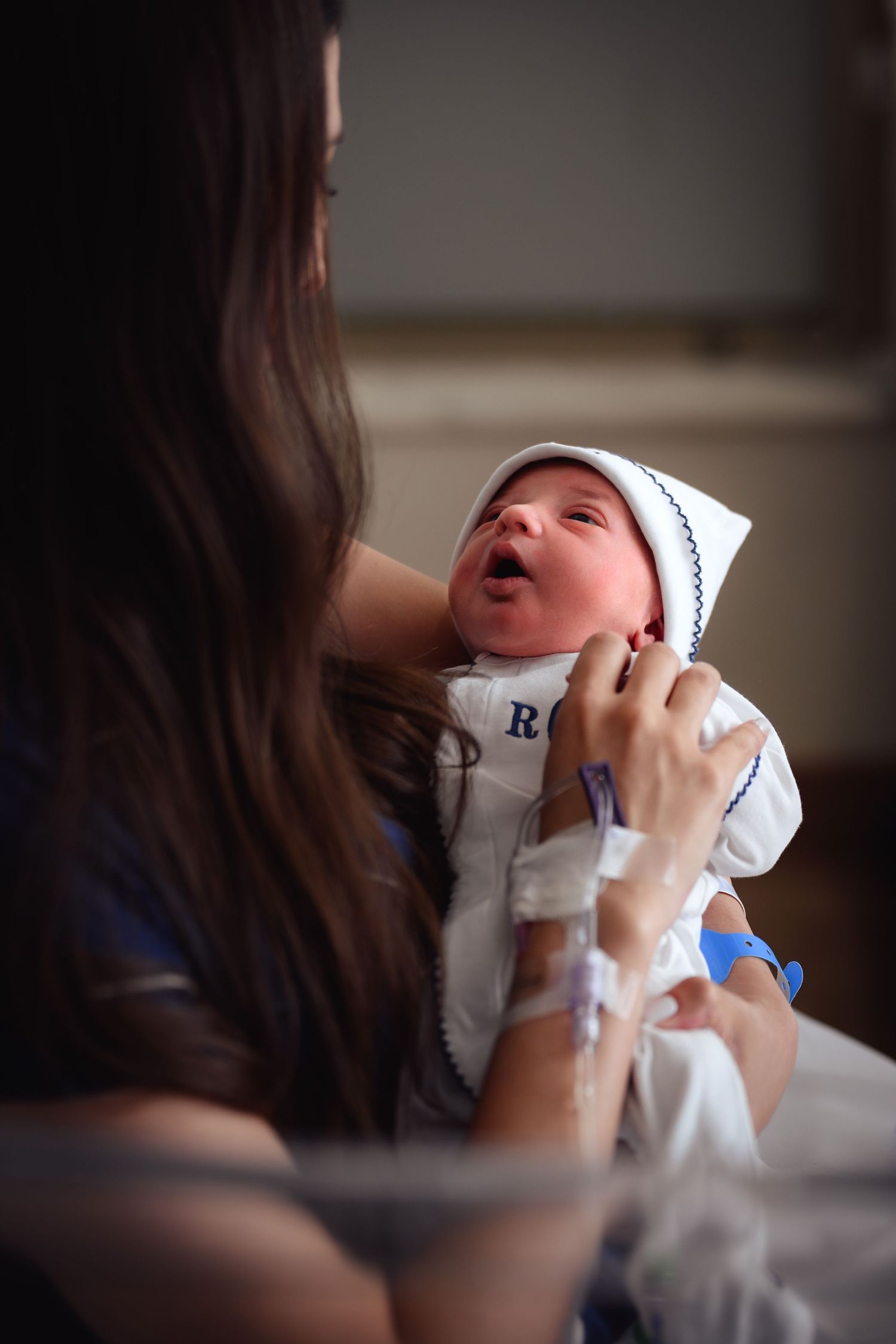 A series of intimate photos showing a newborn baby being fed from a bottle in a dimly lit room.