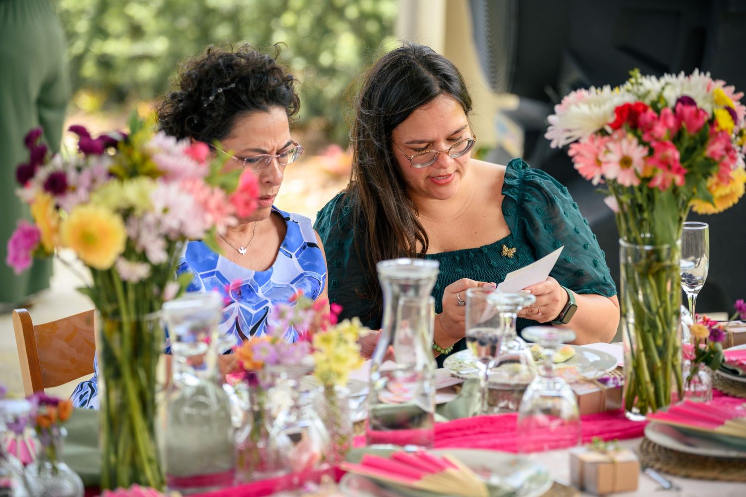 Colorful floral centerpieces and table settings create an elegant outdoor party atmosphere.