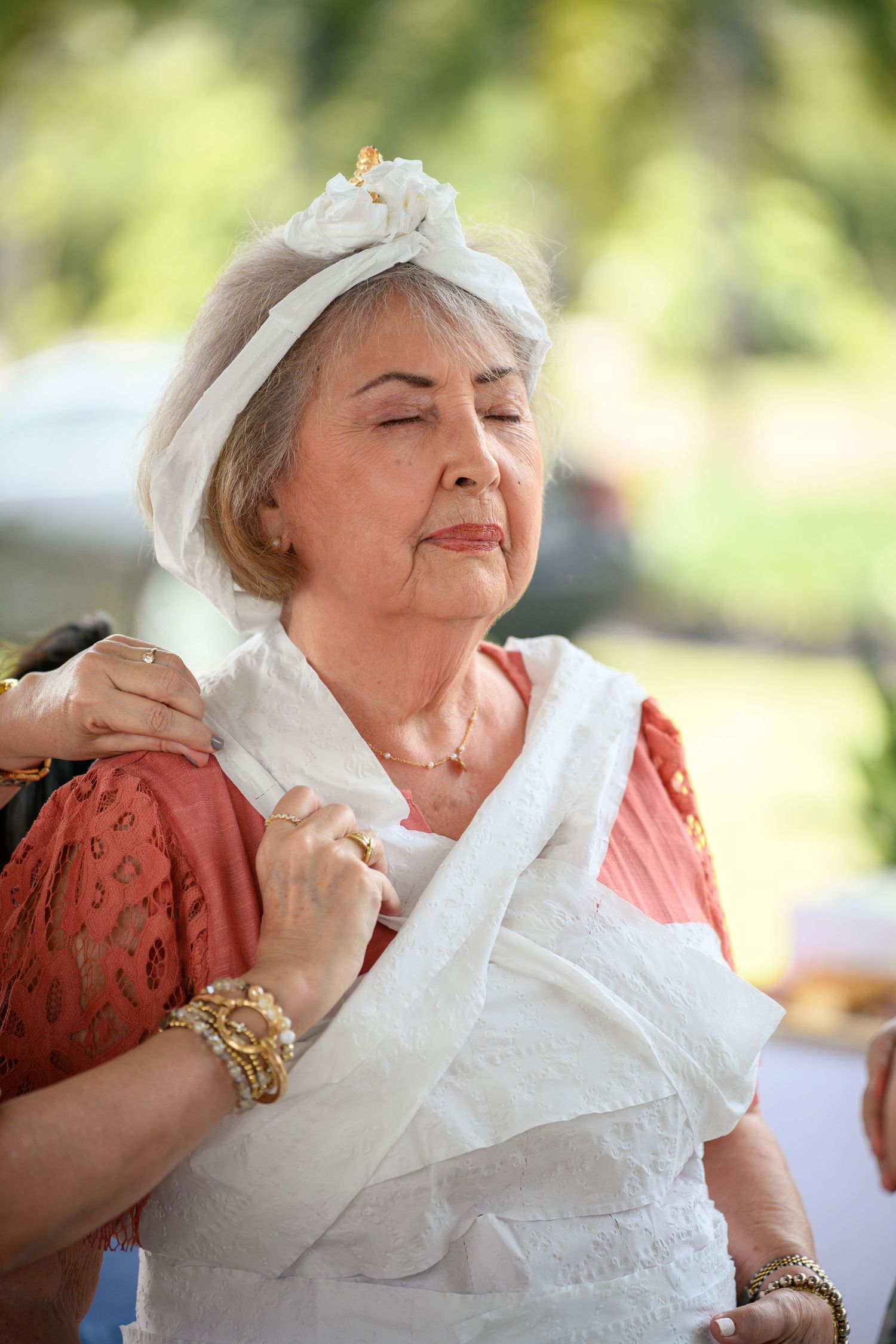 A person in a red dress and white lace collar expresses joy and contentment in a series of candid outdoor shots.