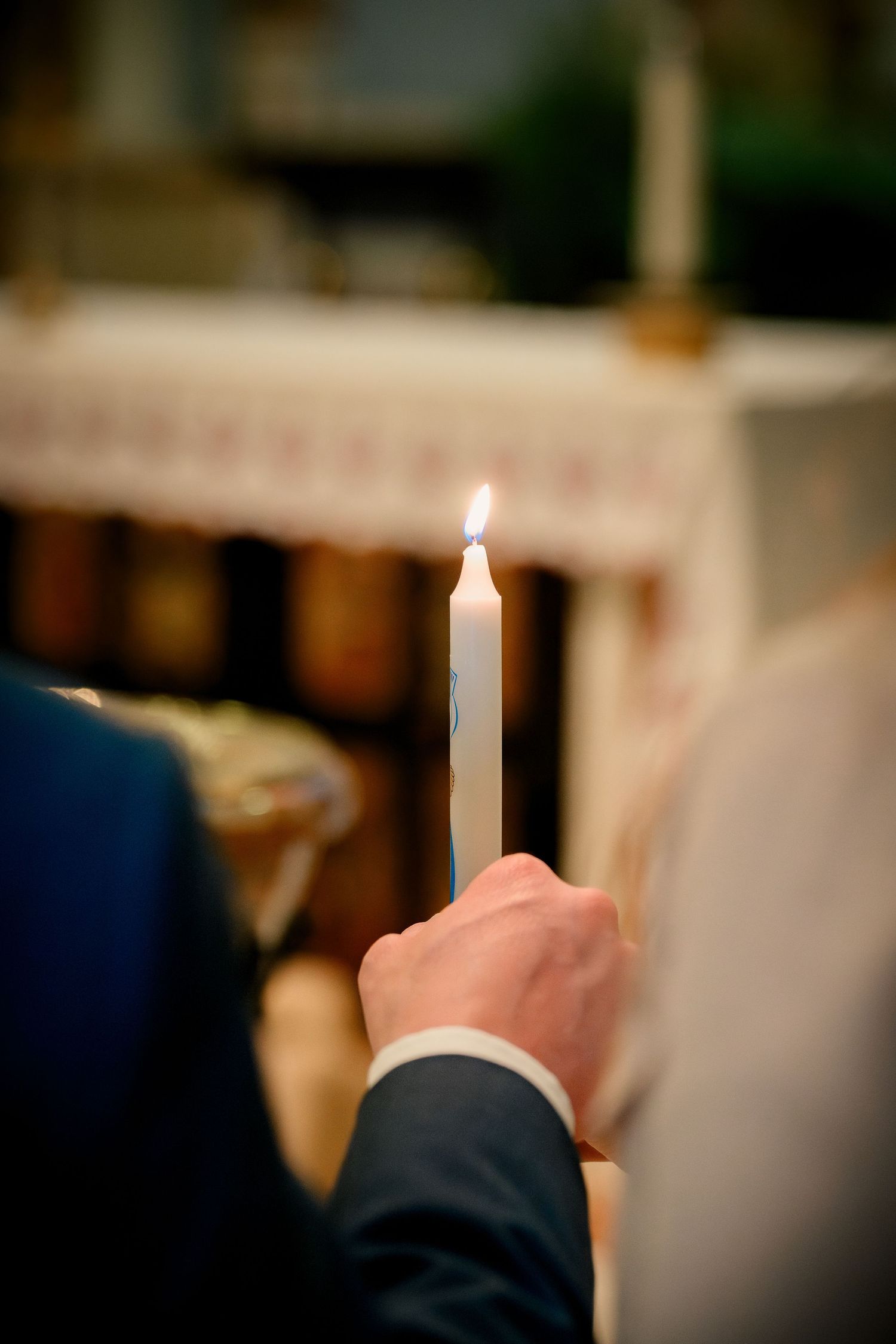 A sequence of lit white candles arranged in a row during an evening ceremony or event.