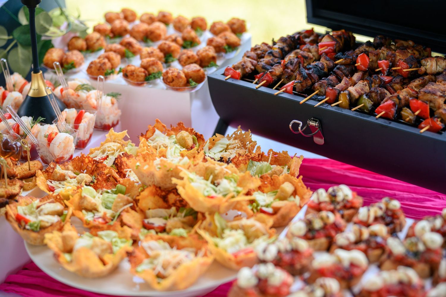 Rows of elegant catering appetizers and hors d'oeuvres displayed on serving platters at an upscale event.