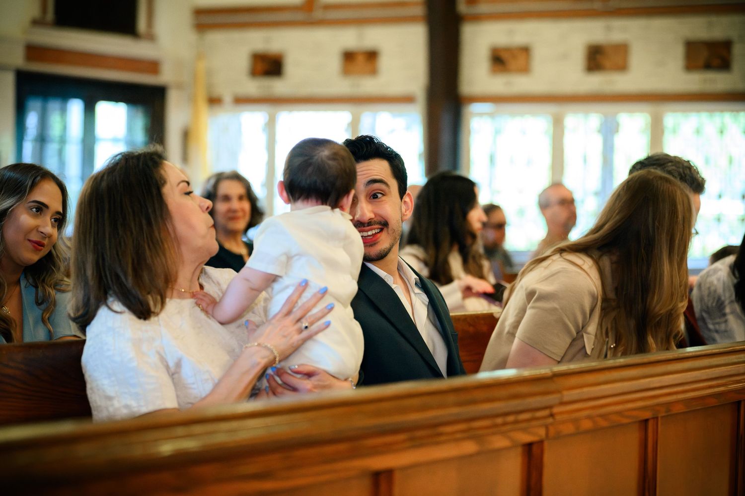 Congregation members sit in wooden pews during a church service.