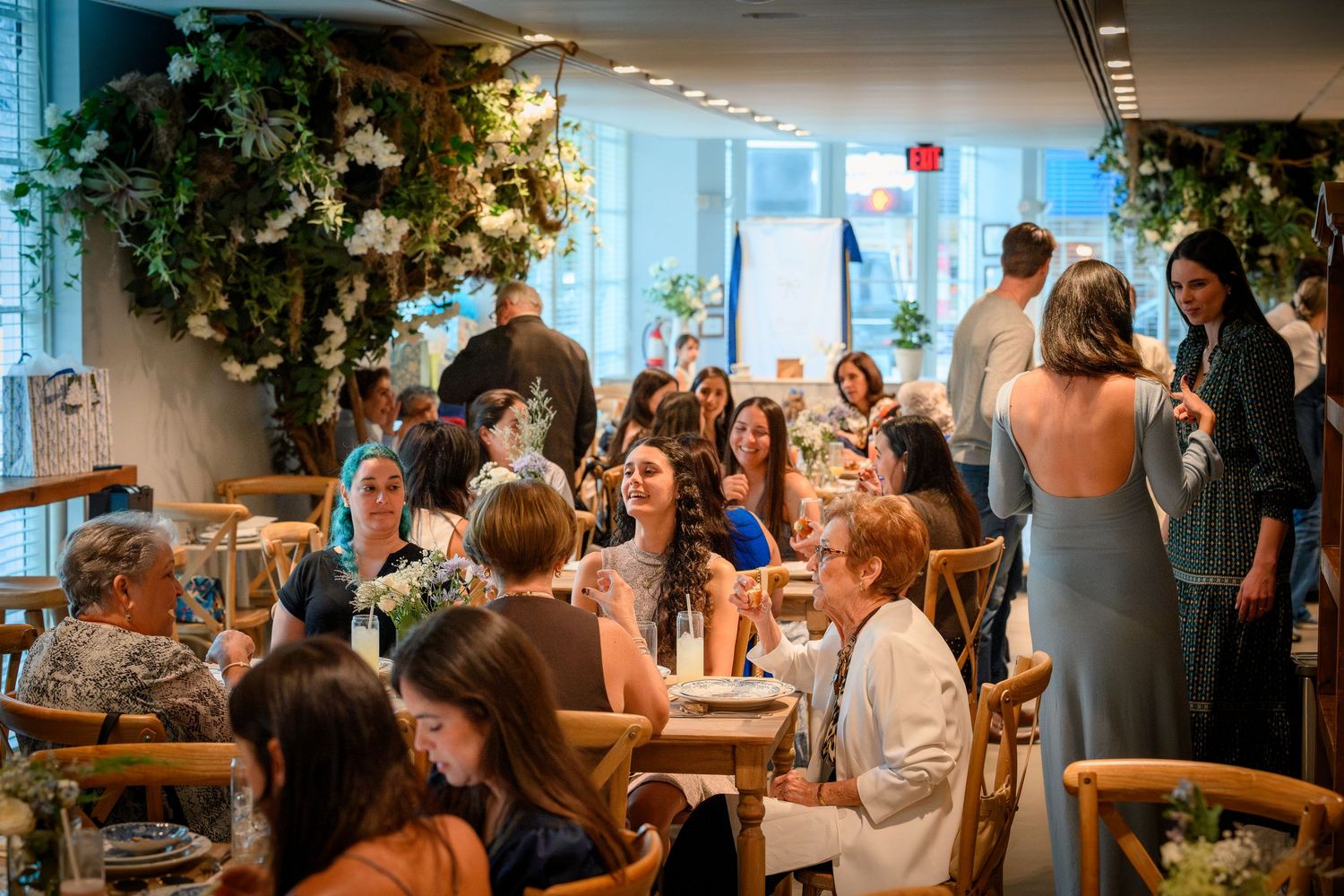 A busy restaurant interior with diners seated at tables during a bustling dinner service.