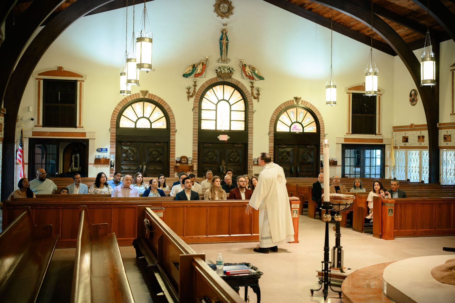 Interior view of a traditional church sanctuary with wooden pews and arched windows.