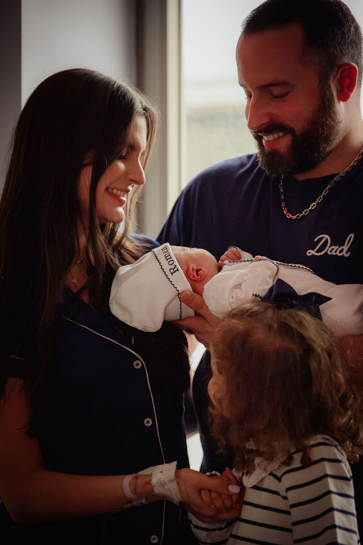 A tender moment between parents and their newborn baby in a series of intimate indoor photos.