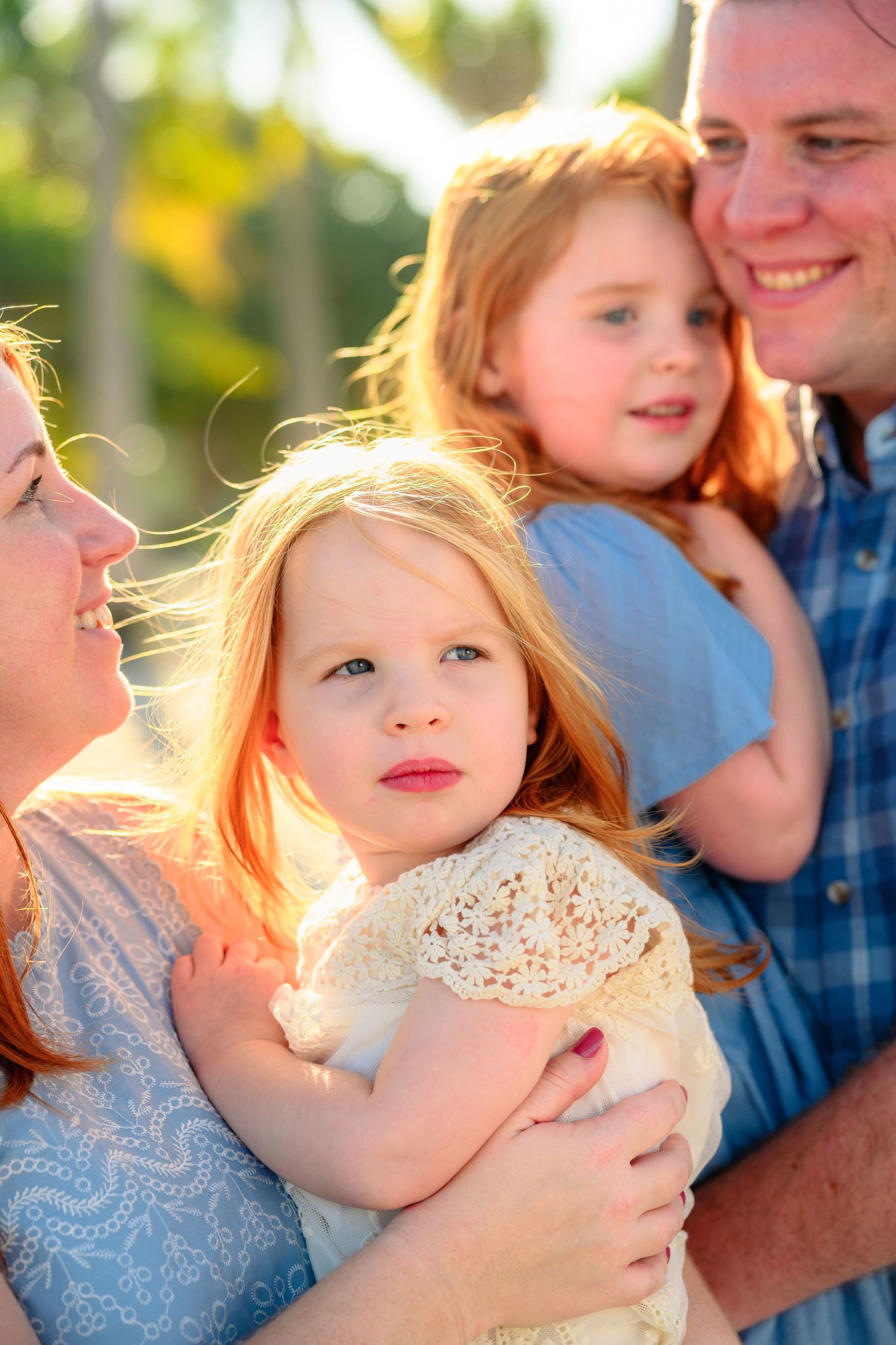 A family shares tender moments together in a series of three outdoor portraits with golden sunlight.