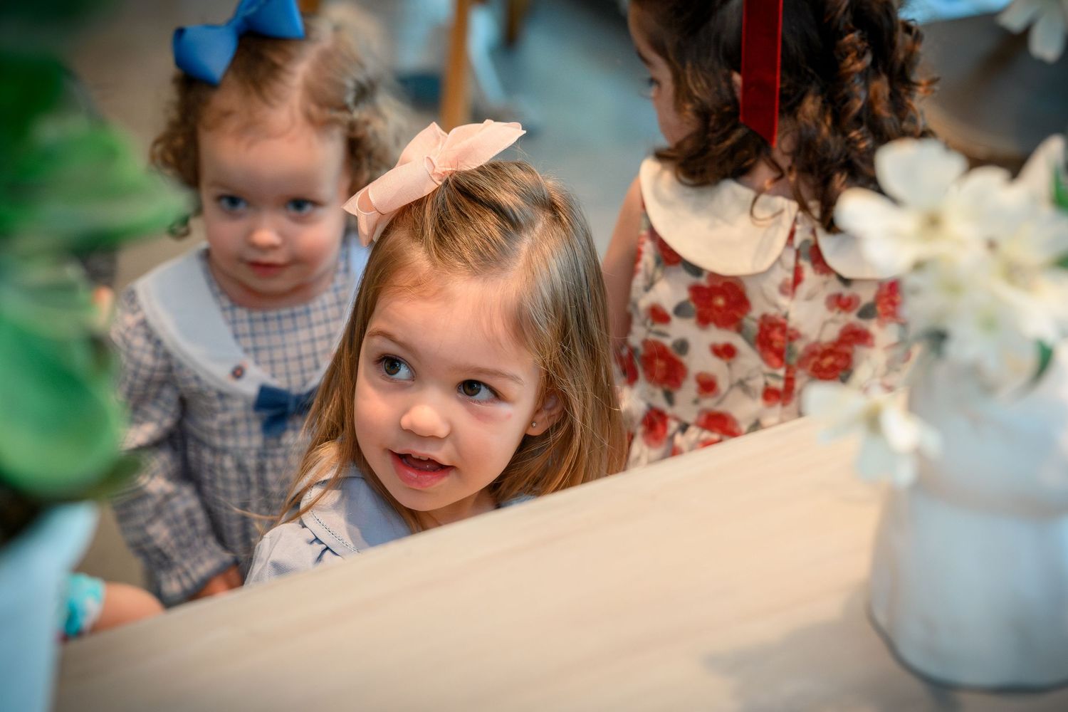A series of connected photos showing children enjoying a tea party with floral decorations and table settings.
