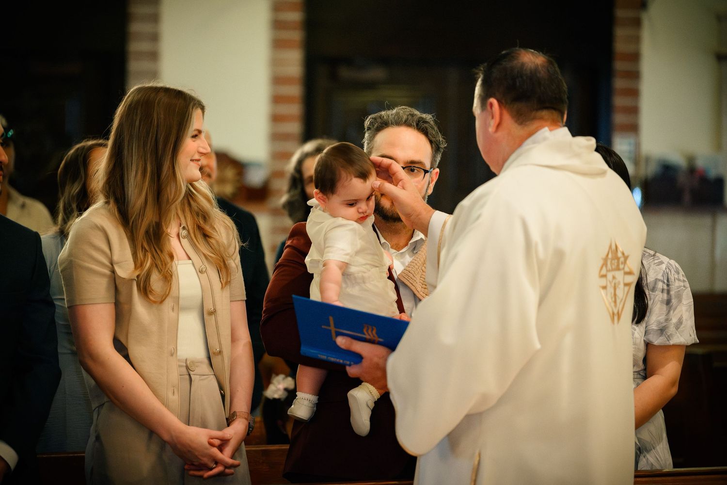 Baptizand receives their blessing at a Catholic Baptism.